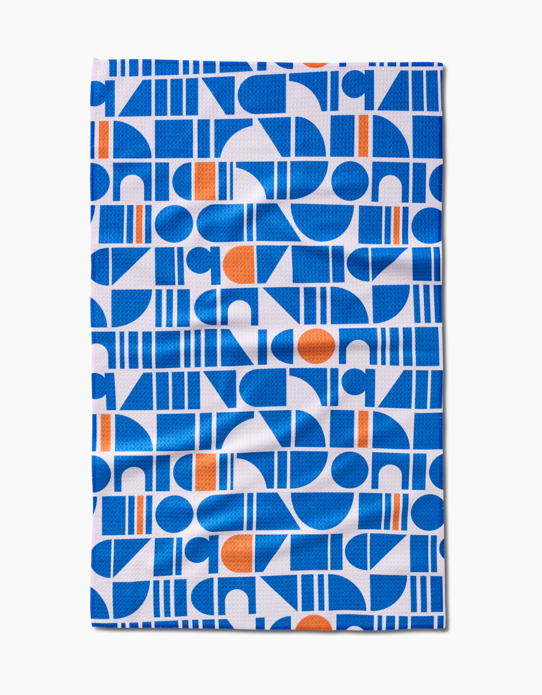 Ultra Marine Harmony by Happy Hemera is a rectangular cloth with blue and orange geometric shapes on white. Made from ultra-absorbent Geoweave fabric, it features circles, semicircles, rectangles, lines, and a slightly wrinkled look.