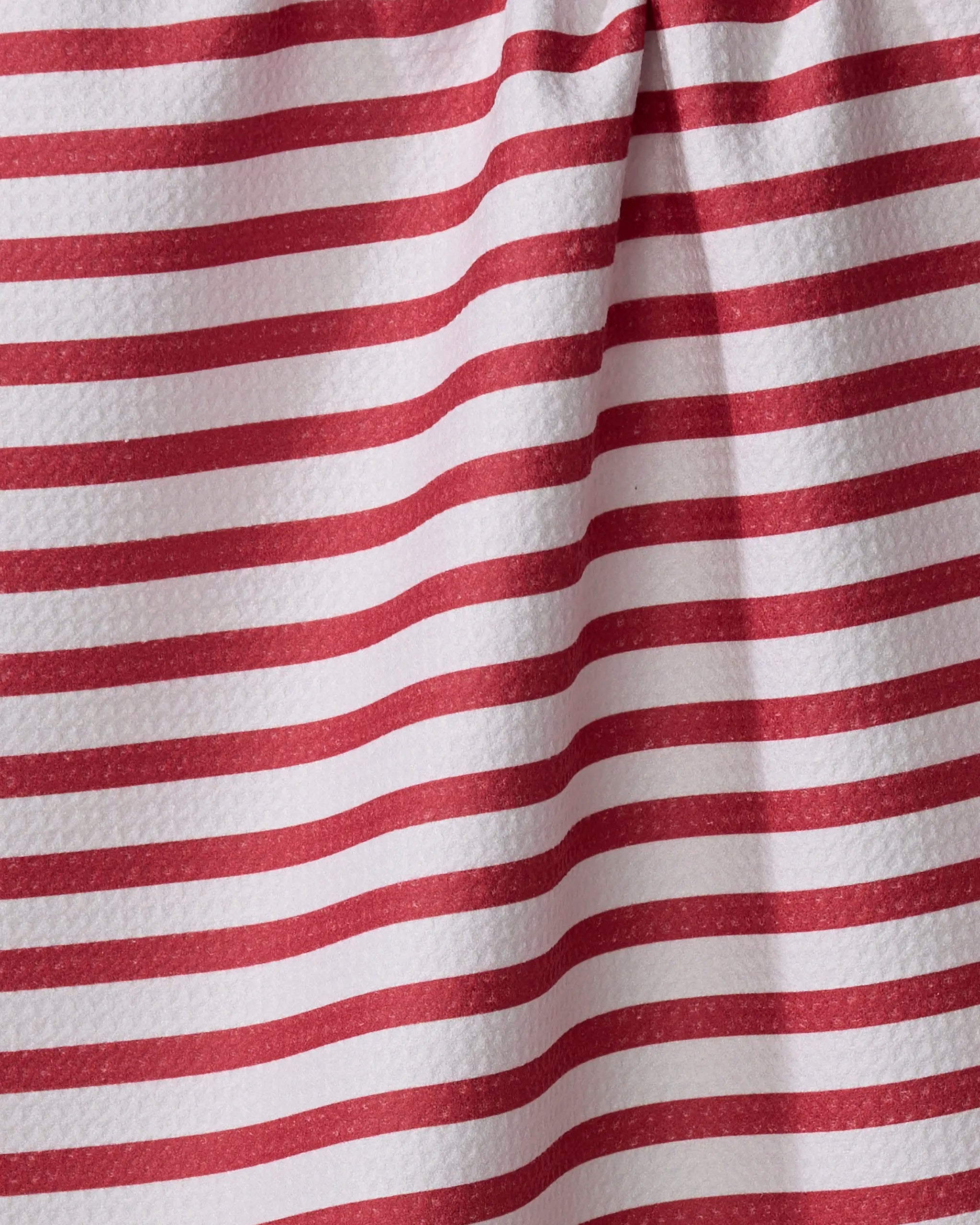 Close-up of the Mindfulnice "USA Stripes" tea towel featuring horizontal red and white stripes with a textured look and a visible fold creating a shadow.