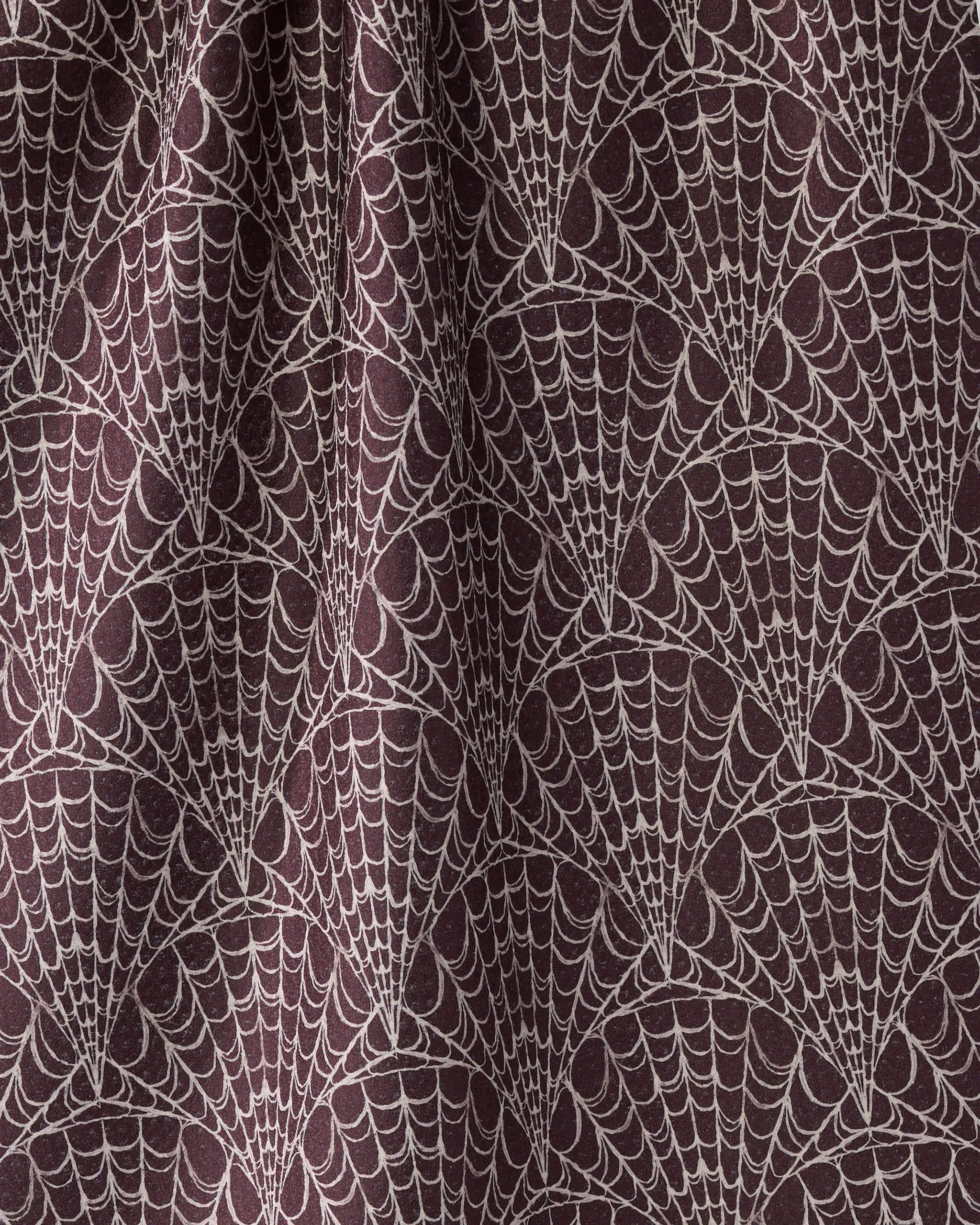 A close-up of Geometry's Velvet Cobwebs shows dark fabric with a repeating pattern of light spiderwebs, creating a textured and slightly wavy look.
