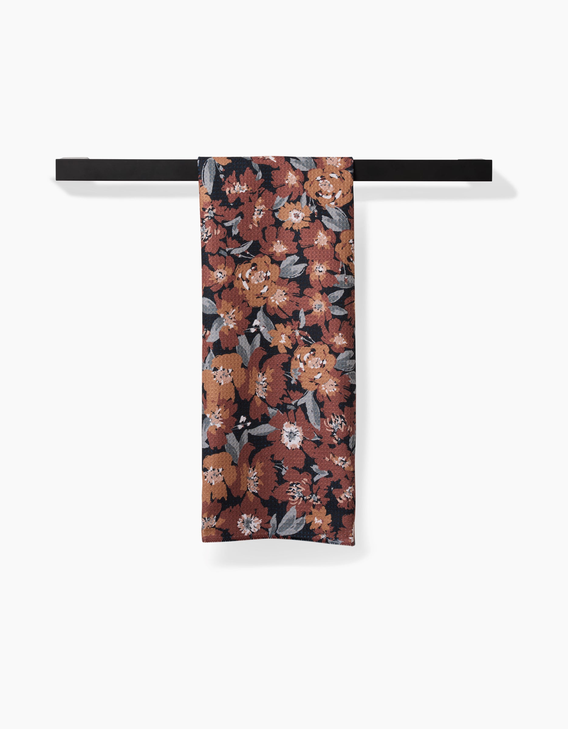 A Hufton Studio Vintage Floral Natural tea towel with a red, orange, white, and gray floral pattern hangs neatly over a black bar, featuring ultra-absorbent Geoweave fabric on a white background.