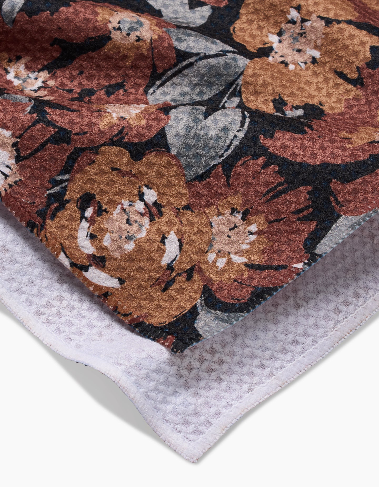 A close-up of Hufton Studios Vintage Floral Natural towel, showcasing a brown, orange, and gray floral pattern on one side with ultra-absorbent white Geoweave fabric on the reverse.