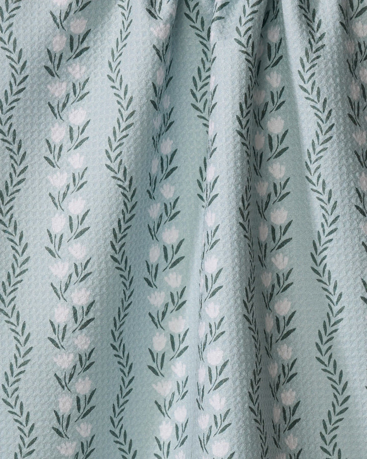 Vintage Floral Stripe by Teri the Butter features light green textured fabric made from recycled materials, with white tulip-like flowers and dark green leafy branches in gentle folds.