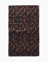 The Hufton Studio Vintage Grass Black tea towel is rectangular, made from Geoweave fabric, and features a black background with brown and tan leafy branches and small flowers, shown flat with slight wrinkles.