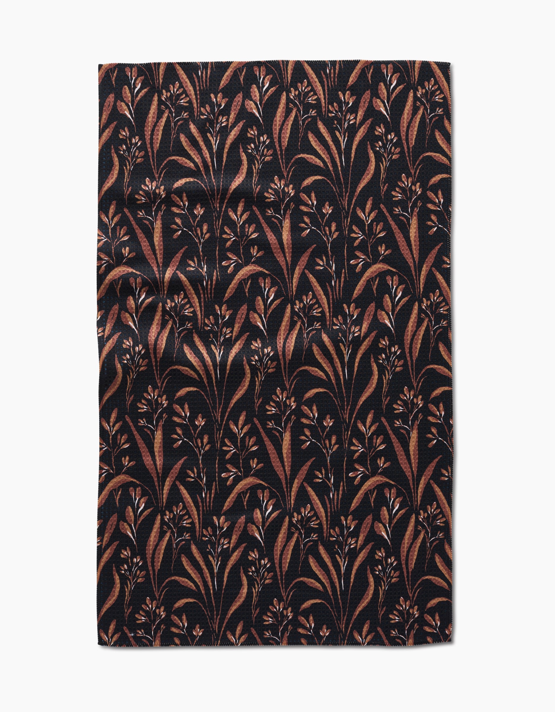 The Hufton Studio Vintage Grass Black tea towel is rectangular, made from Geoweave fabric, and features a black background with brown and tan leafy branches and small flowers, shown flat with slight wrinkles.