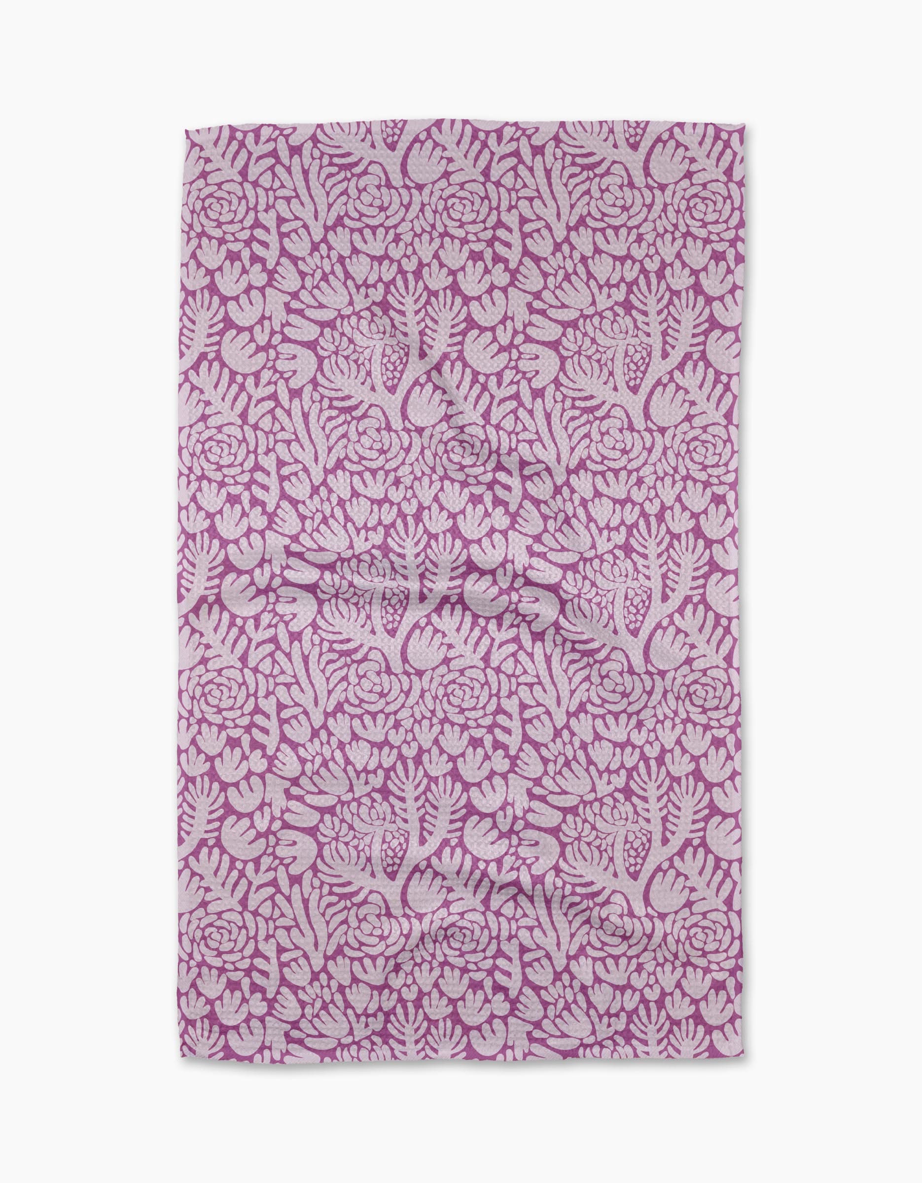 The Violet Paper Flowers tea towel by Katie OShea features an intricate floral pattern in pink and white, with densely arranged flowers and leaves—perfect for adding charm to any kitchen.