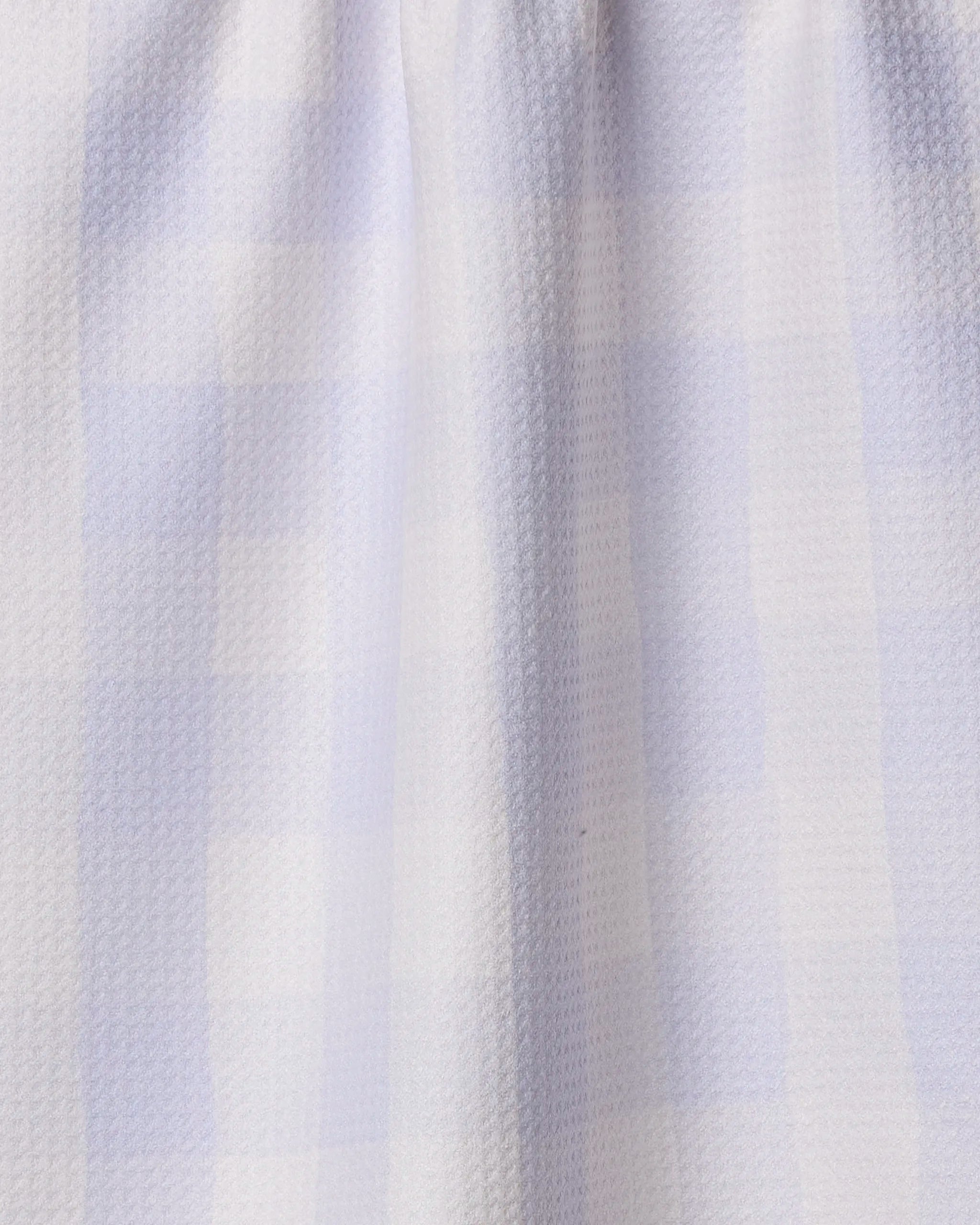 Close-up of the Violetta kitchen towel by Geometry, featuring a light blue and white checkered design, crafted from soft recycled materials with a subtle textured pattern and gentle folds.