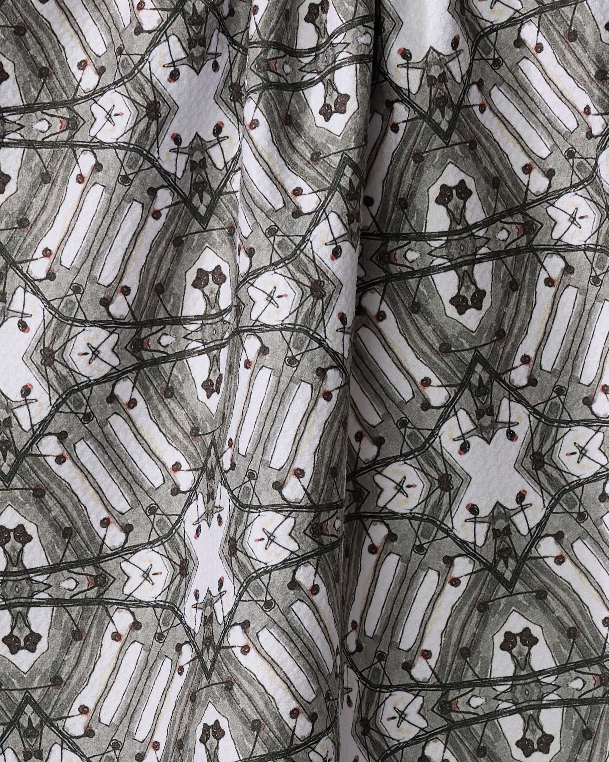 A close-up of the Walk The Line Shimmy by Katherine Berkeley, a recycled kitchen towel with symmetrical black, gray, and brown geometric lines on white. Fabric folds enhance depth and texture in this ultra-absorbent design.