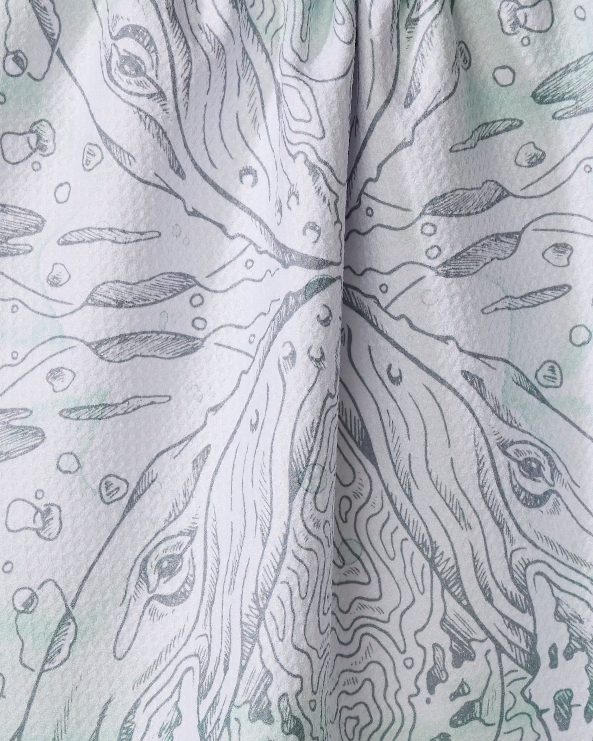 Close-up of Skye Walker’s "Whale" tea towel—quick-drying, made from recycled fabric, and featuring an abstract gray symmetric pattern with whale-like faces, contour lines, and scattered dots.