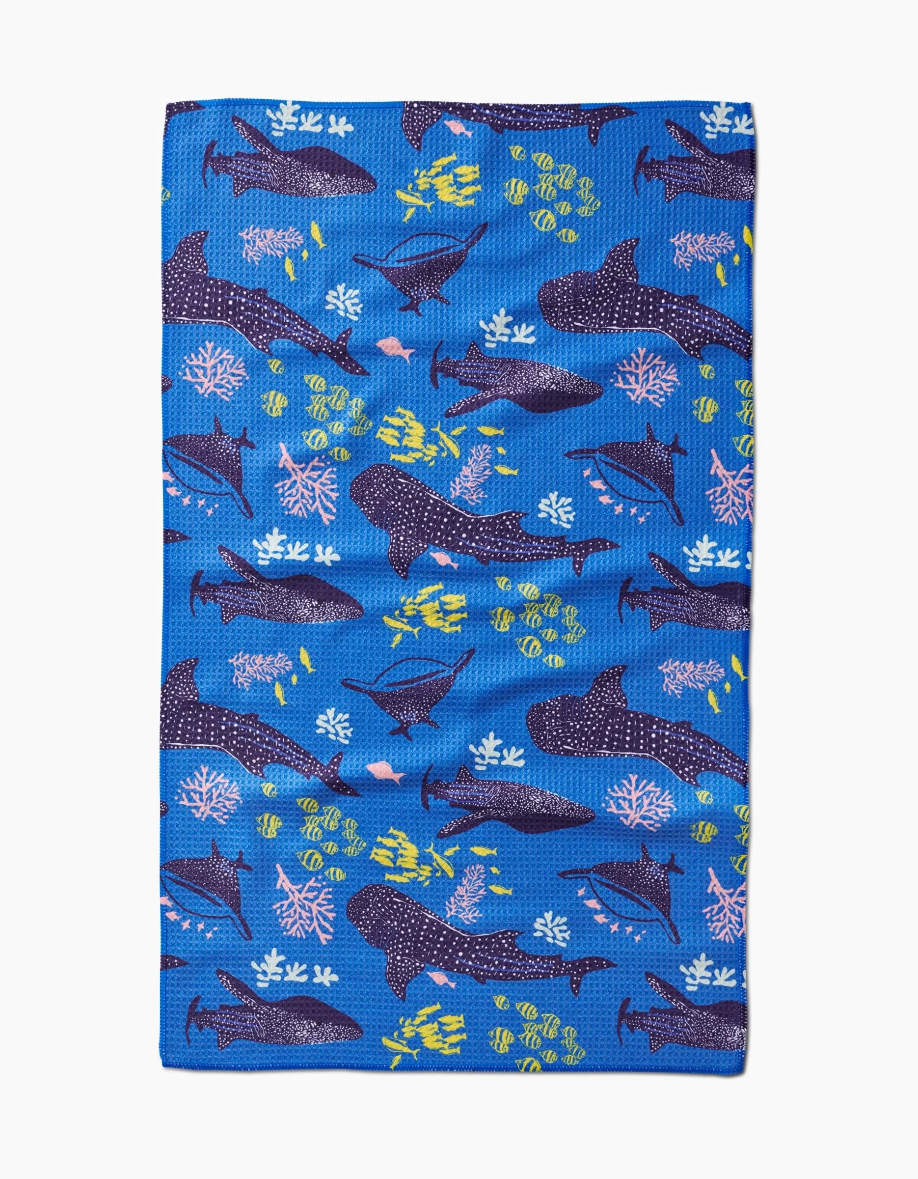 The Whale Shark tea towel by Elisabeth Wing features vibrant Geoweave™ fabric with playful sharks, fish, and coral in navy, blue, pink, yellow, and white—perfect for adding marine-themed color to any kitchen.