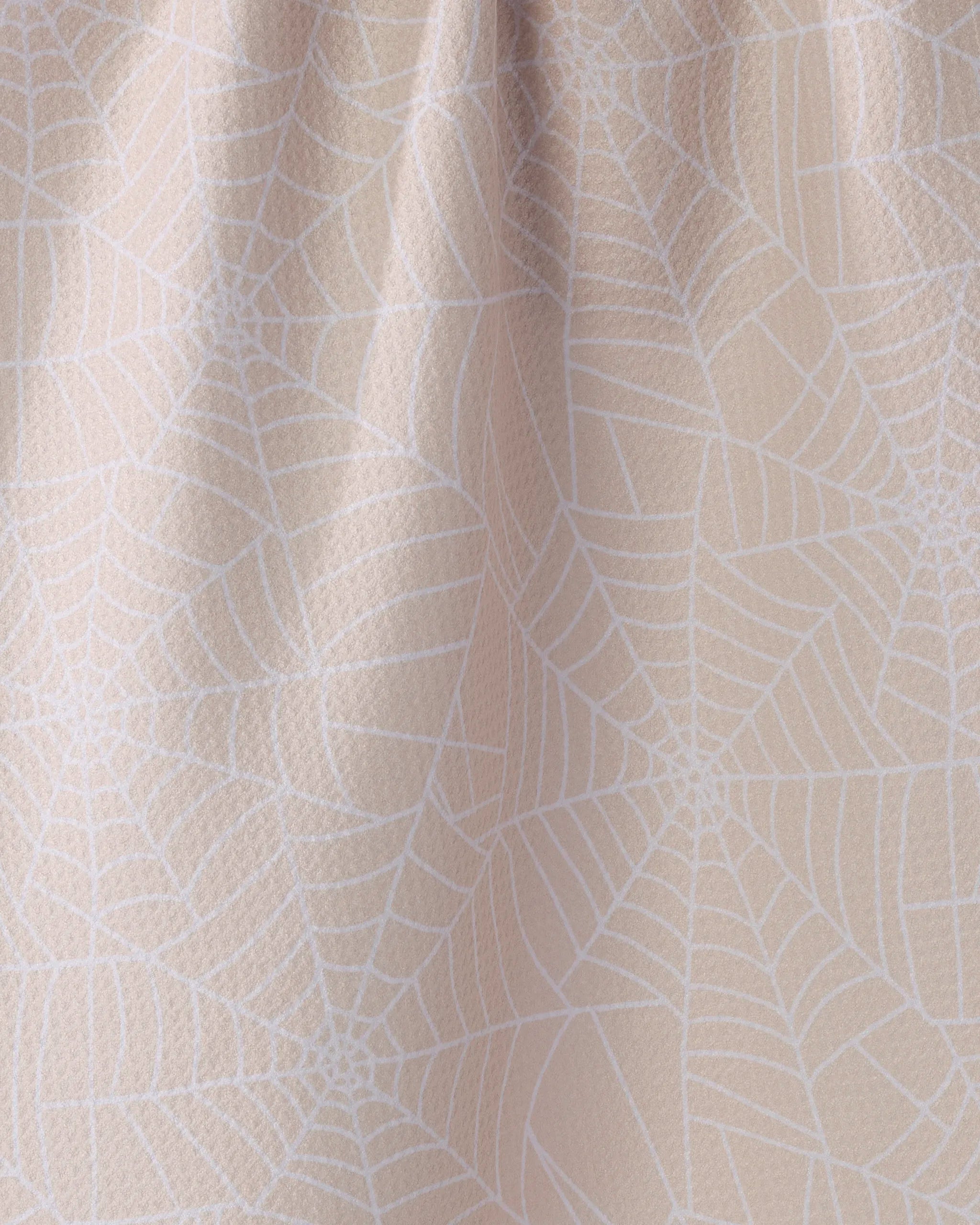 Whisper Web by Geometry features a beige fabric with a subtle white spiderweb pattern and gentle texture—ideal as an eco-friendly kitchen or absorbent dish towel.