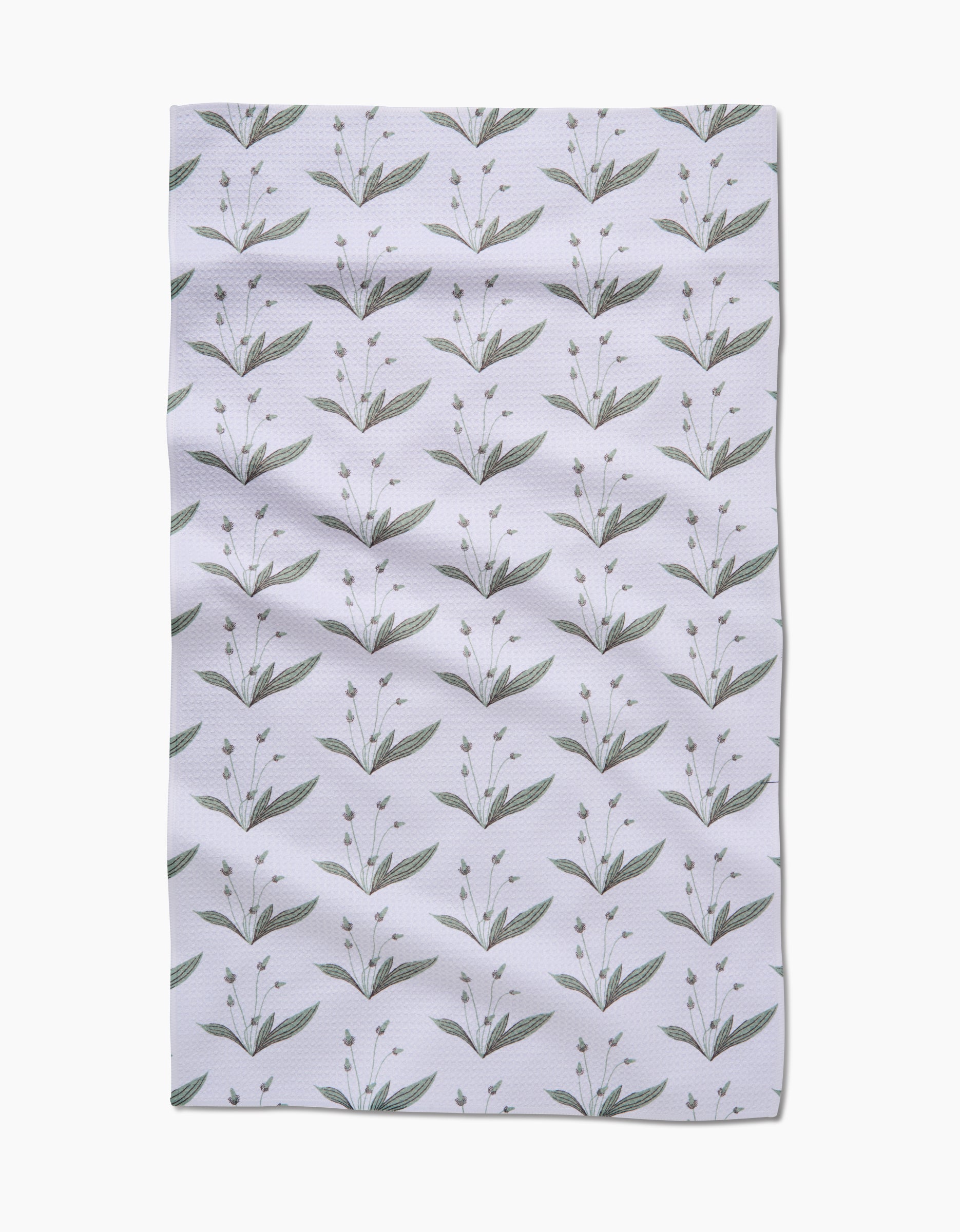 Wild Leaves Green by Linda Fox is a white Geoweave fabric with neat rows of simple green botanical illustrations—each showing leaves and small buds—arranged in a repeating pattern. The fabric has a slightly wrinkled appearance.