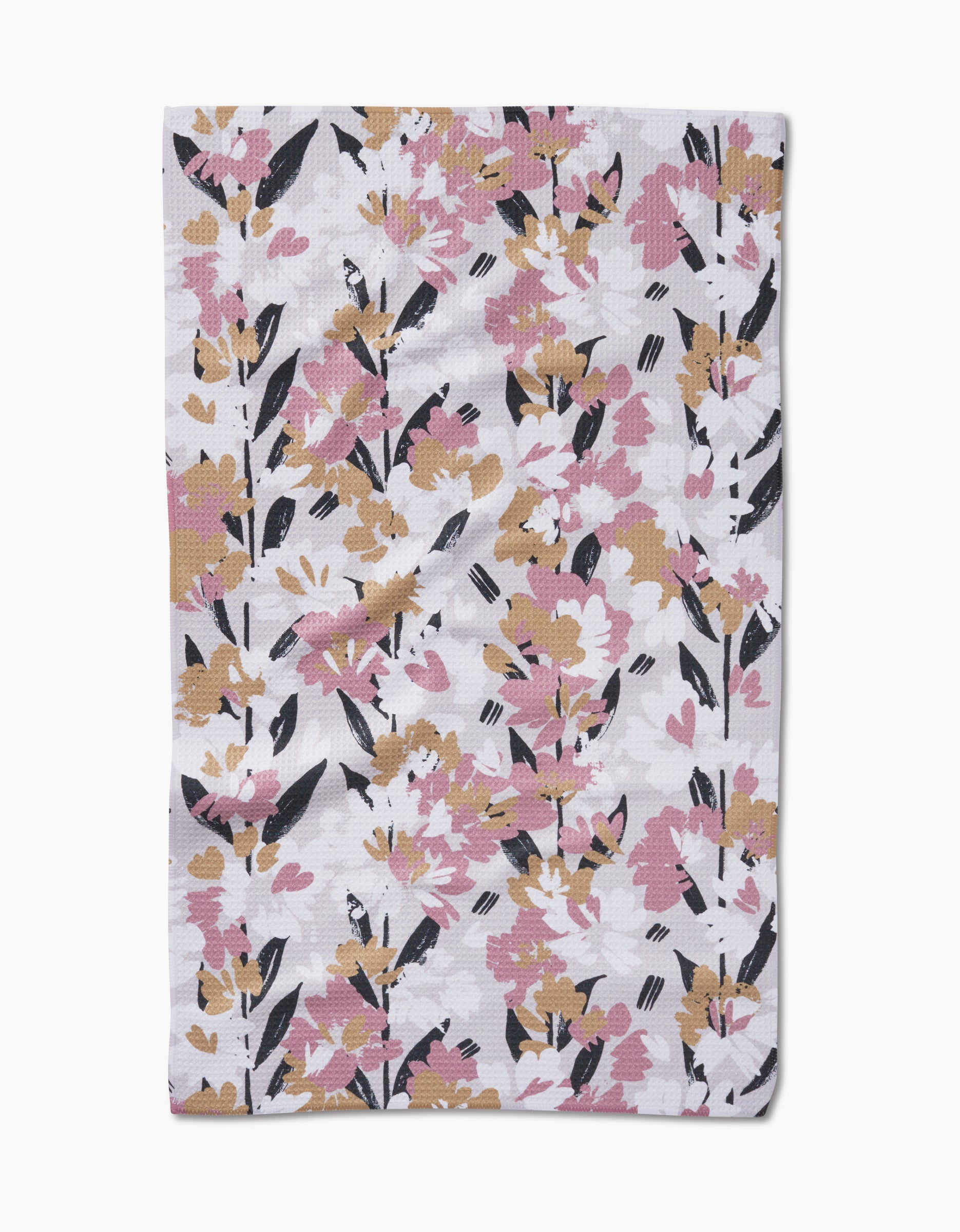 The Toboggan Avenue Wilderness Floral Tea Towel features a white background with pink, mustard yellow, and black flowers and leaves. Made from recycled materials, it adds an eco-friendly touch to your kitchen.