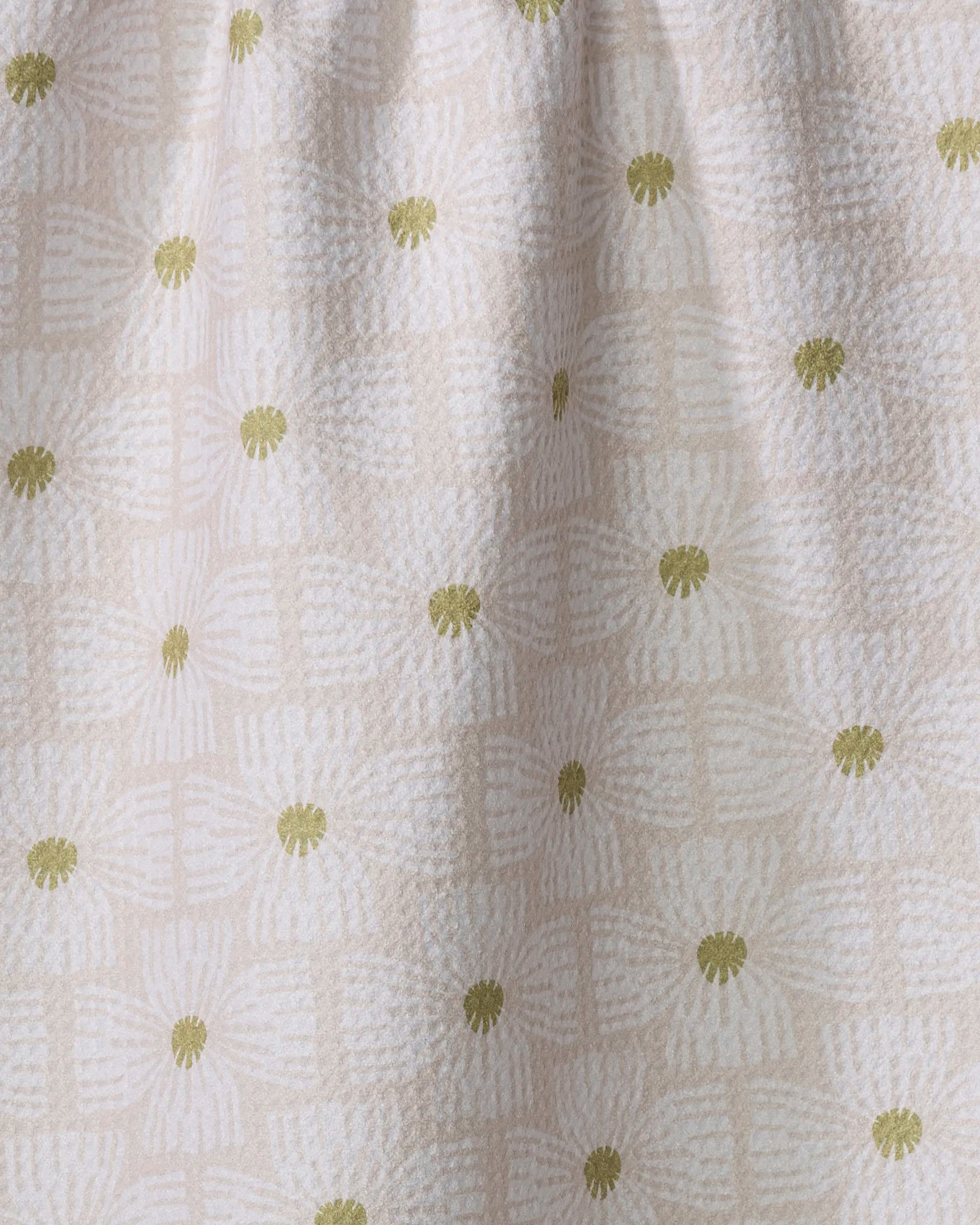 The Wildflower kitchen towel by Ash Cascade features a cream hue with light beige geometric patterns and olive-green floral accents, combining elegant style with sustainable, recycled materials.