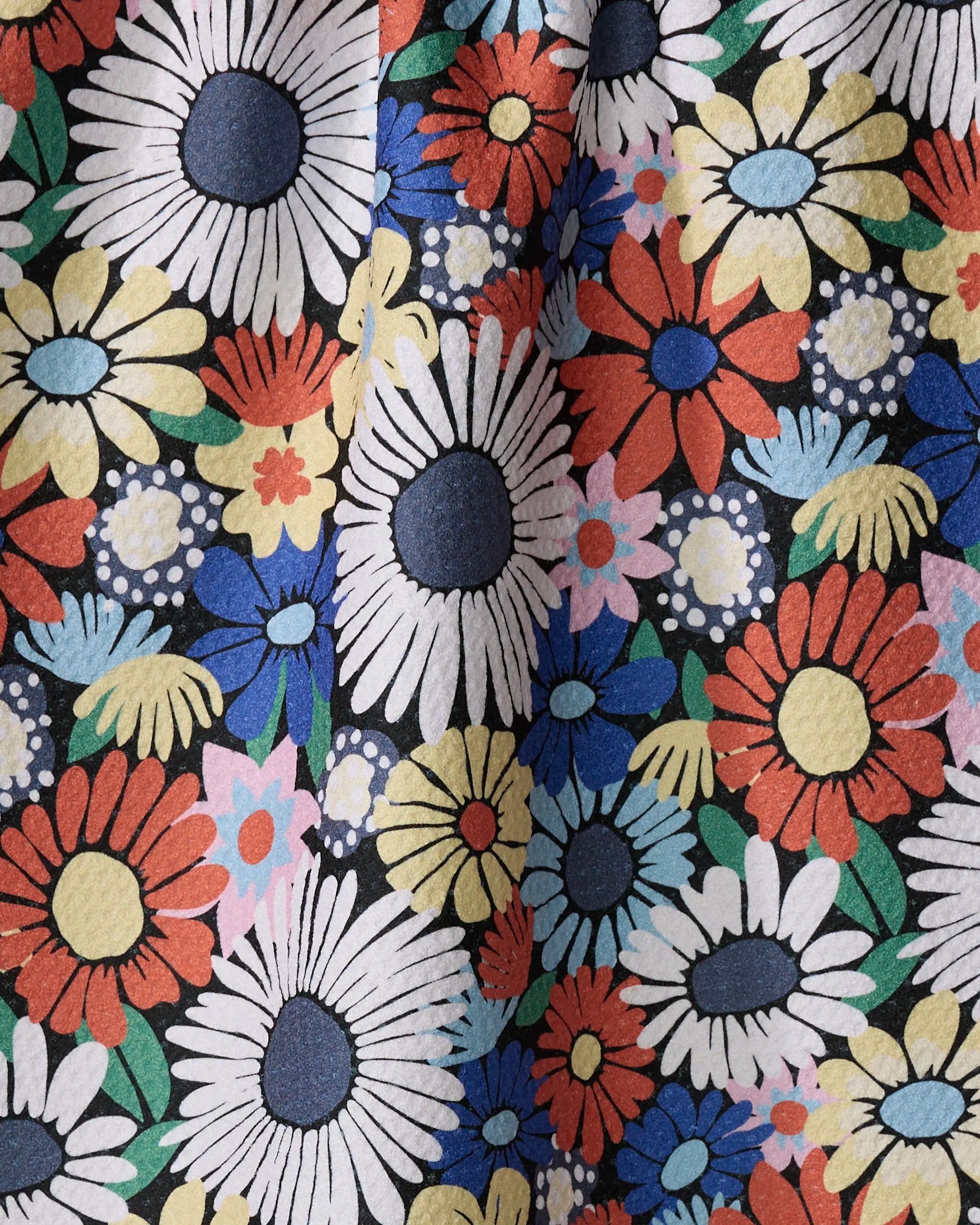 The Claire Iglesias "Wildflowers Bouquet" tea towel showcases a vibrant floral pattern with large white, red, yellow, and blue daisies, green leaves, and small blooms on a dark background. This ultra-absorbent towel is both functional and eye-catching.