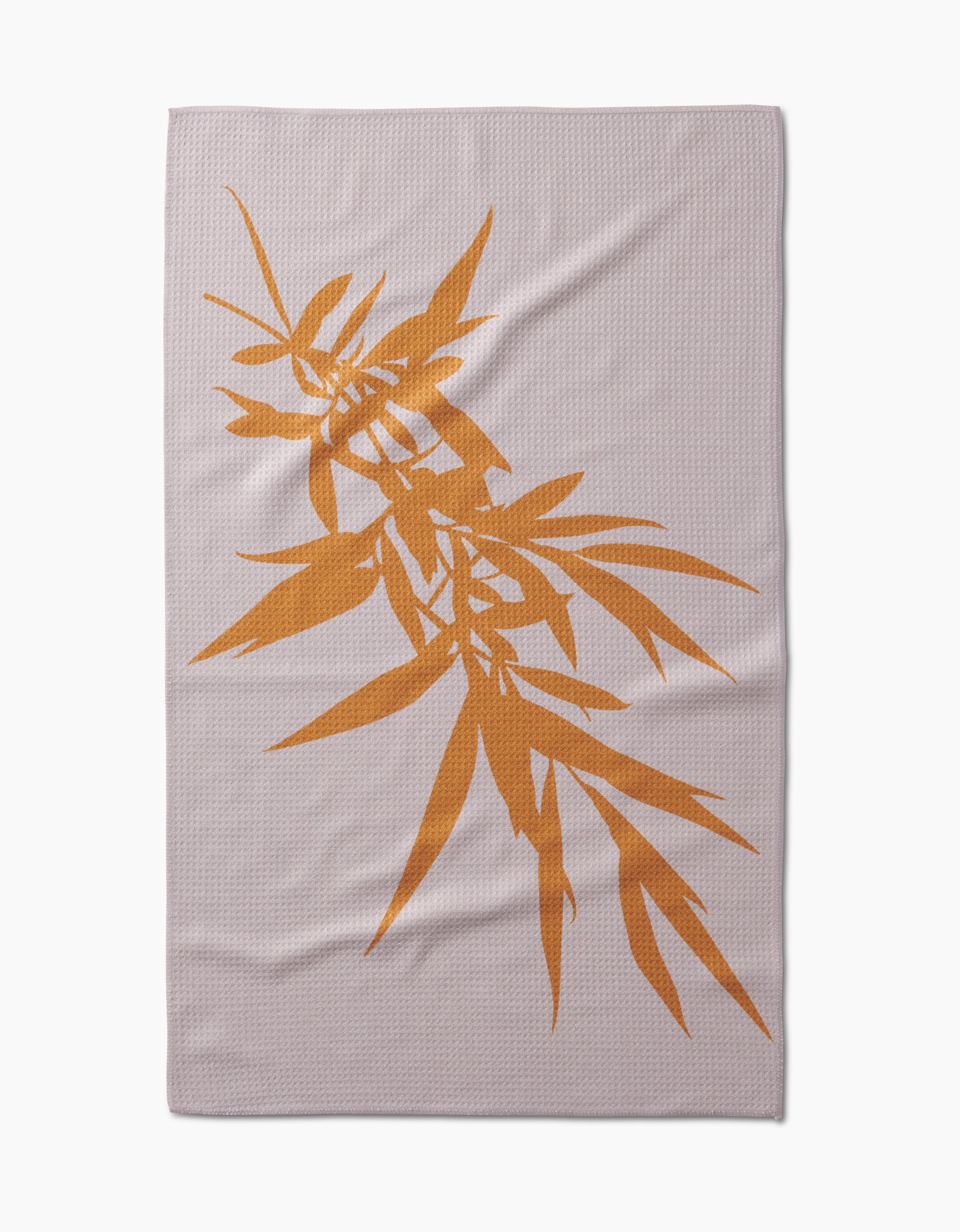 The Willow blanket by PrintedPlant features a large orange bamboo leaf design diagonally across light gray Geoweave fabric.