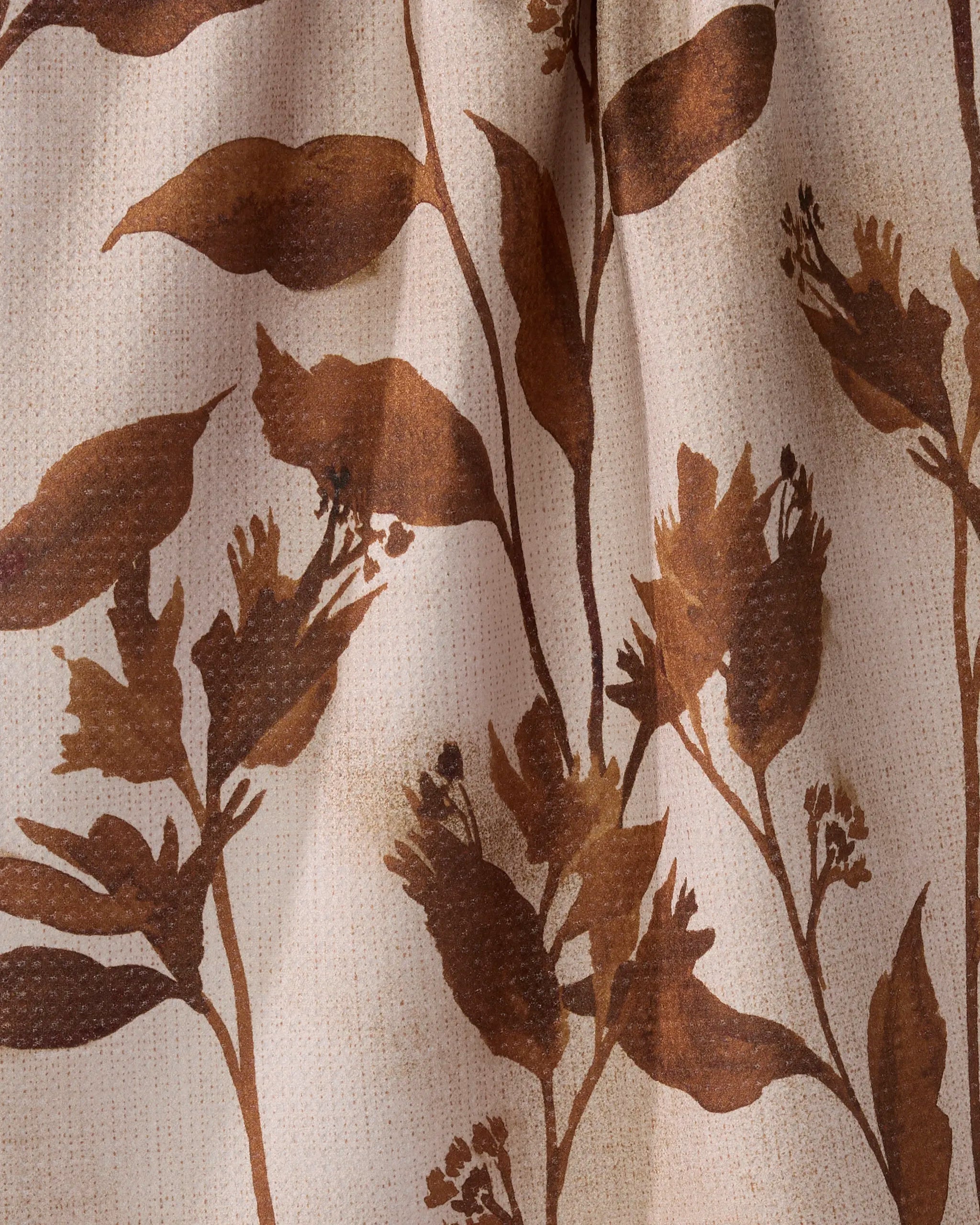 A close-up of Geometry’s Willowmere fabric shows a brown botanical leaf and flower pattern on beige with visible texture and shading—ideal for a stylish recycled kitchen towel.