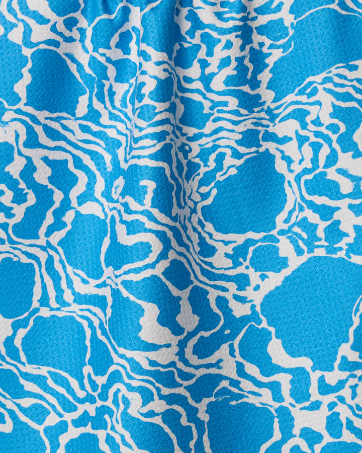 Windward by Geometry features a blue and white abstract pattern with wavy lines and organic shapes, reminiscent of water—ideal for adding stylish, eco-friendly flair to your kitchen or tea towel collection.