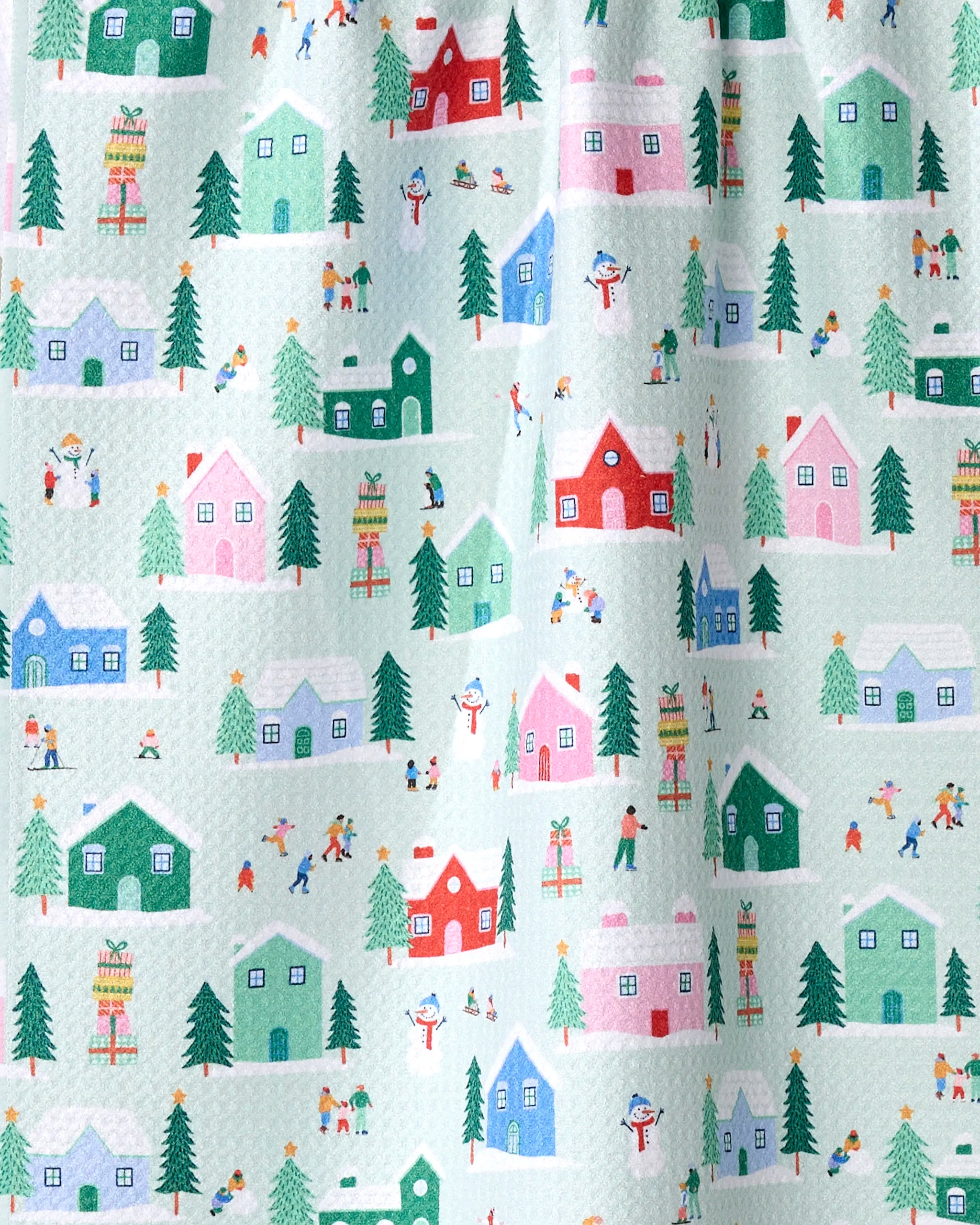 The "Winter Magic" kitchen towel by Ceyda Alasar showcases colorful houses, trees, and people in a festive winter village on light blue—perfect as a recycled-material tea towel.