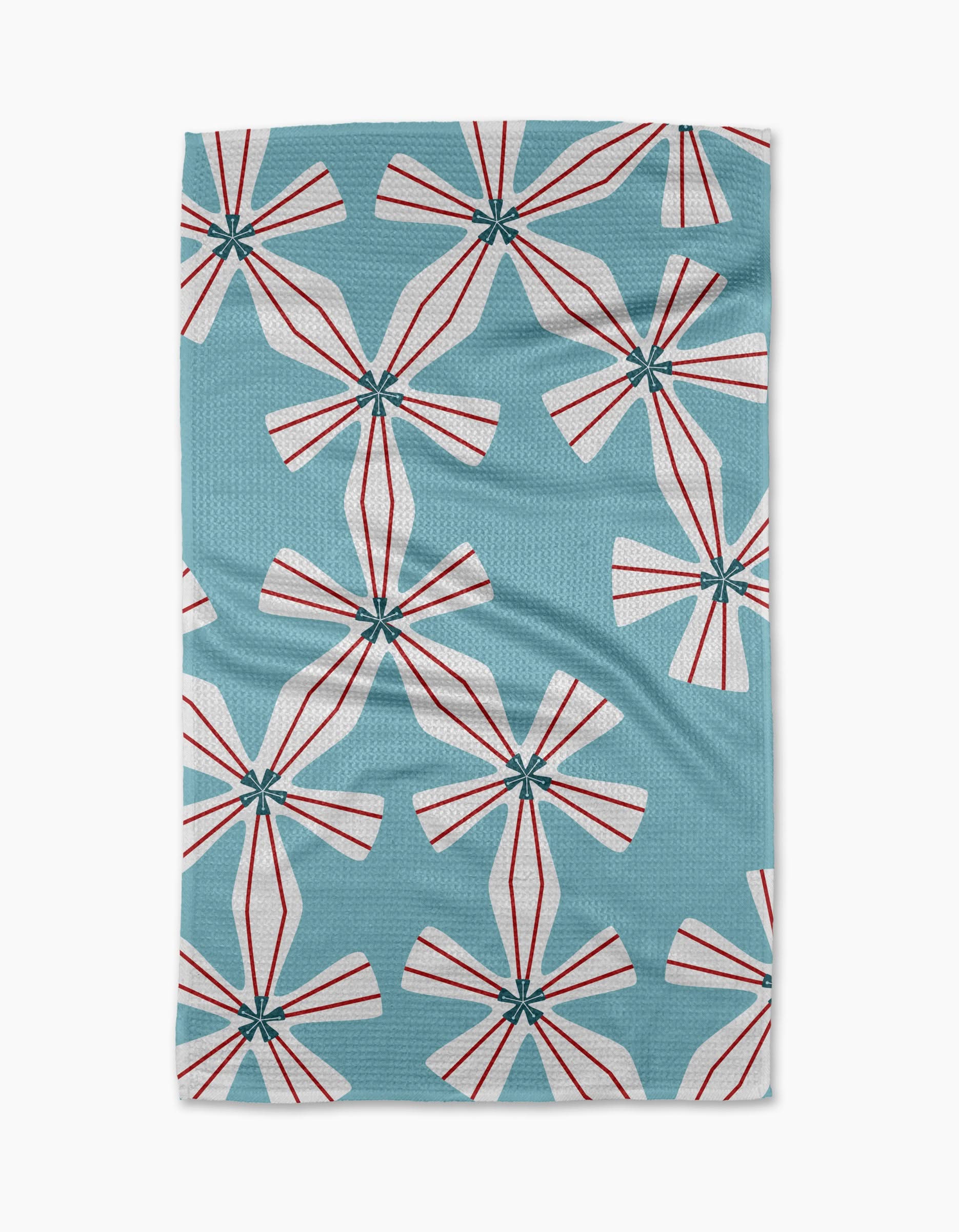 Winter Snowflake by Lizzie Clark is a blue recycled kitchen towel with a repeating pattern of white, pinwheel-shaped flowers and red lines. Its bold, geometric design gives this quick-drying towel a modern, playful appeal.