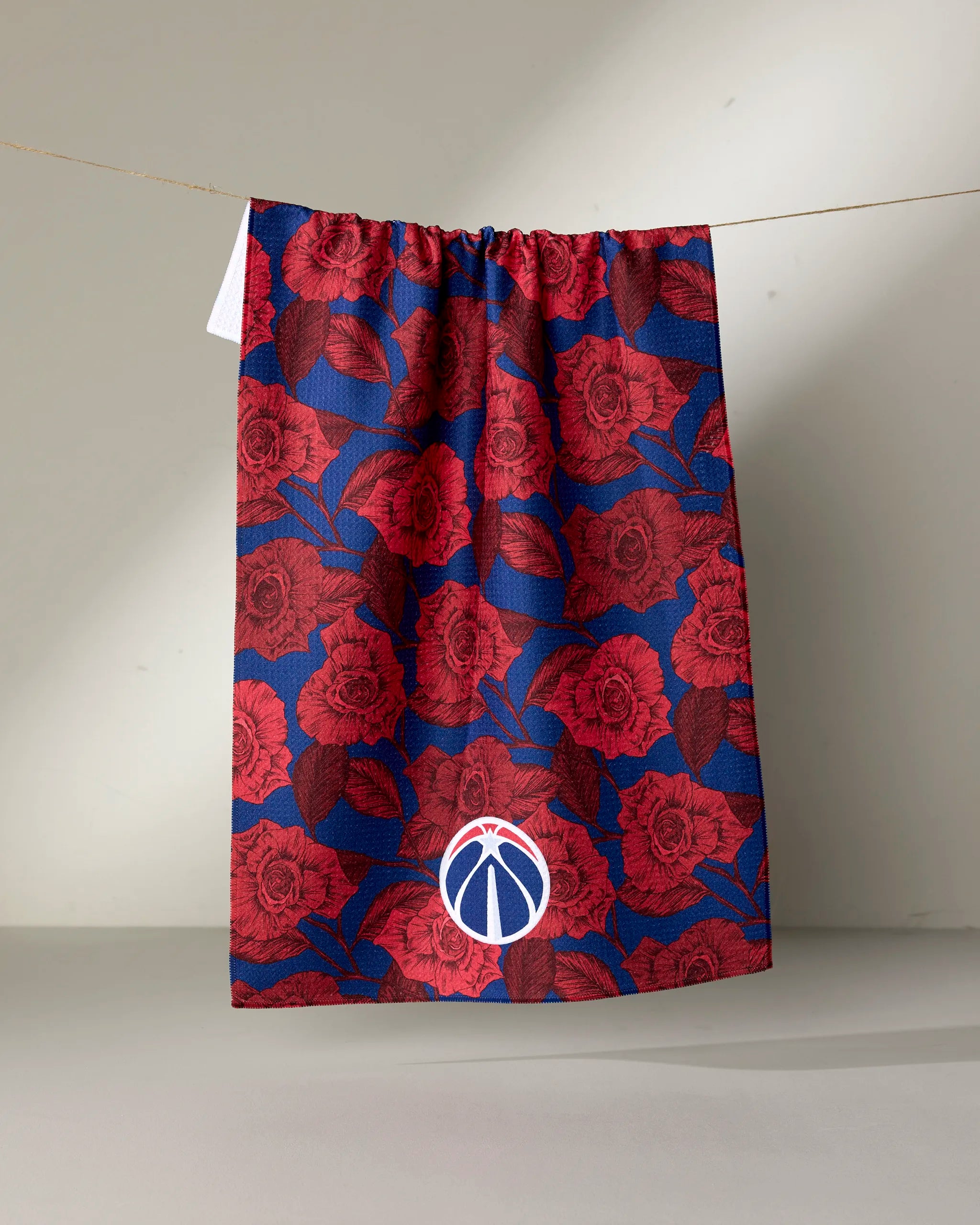 The NBALAB x Geometry Wizards Floral sustainable kitchen towel features a blue and red rose pattern and an officially licensed NBA basketball logo with a red accent near the bottom center.