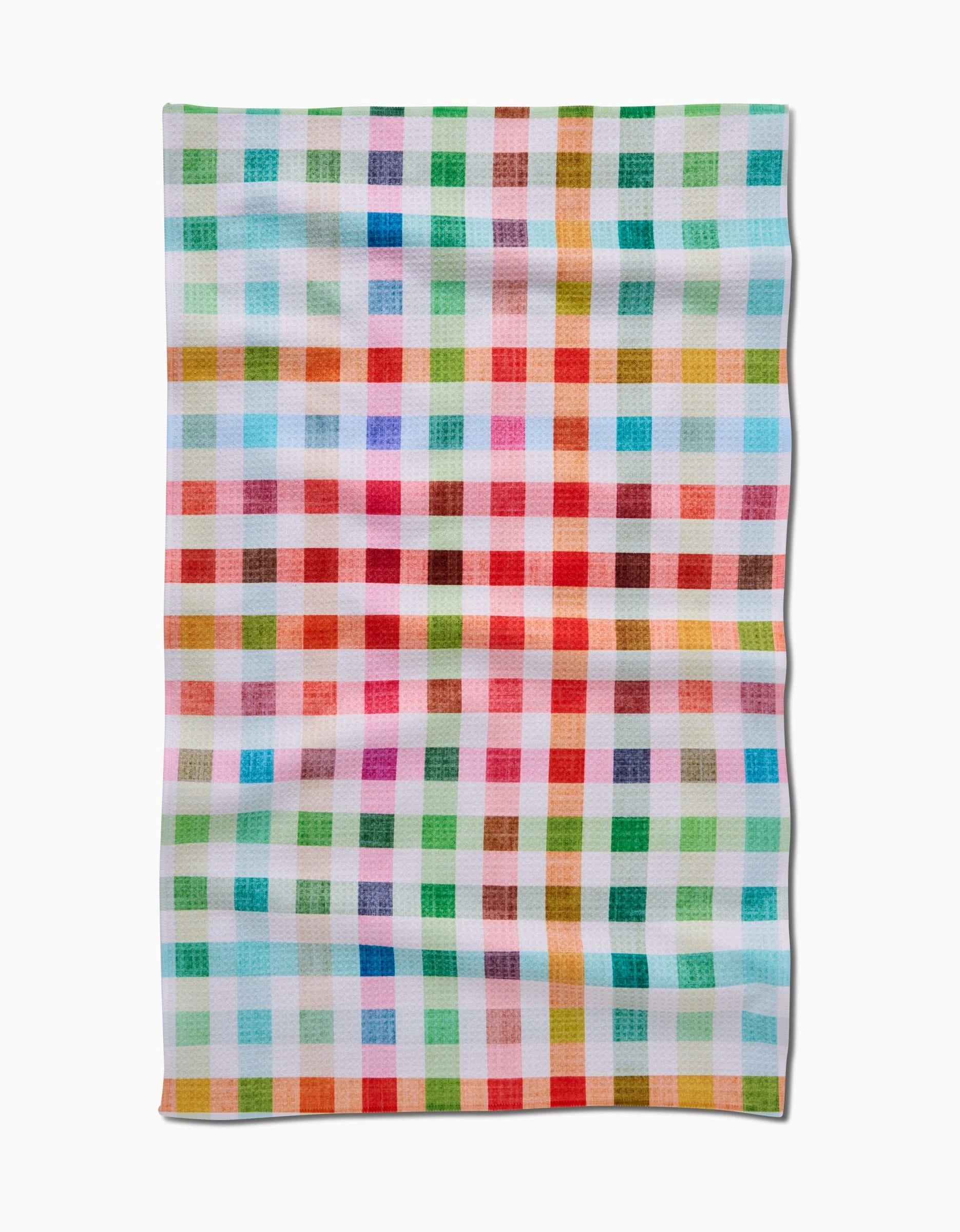 The Pascale Dilger Woven Spring Plaid is a rectangular cloth made from eco-friendly Geoweave fabric, featuring colorful red, blue, green, yellow, pink, and orange checks on a white background.