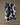 The Geometry Wrangler tea towel by Geometry, featuring a black and white cow print and made from recycled materials, hangs on a string against a neutral background.