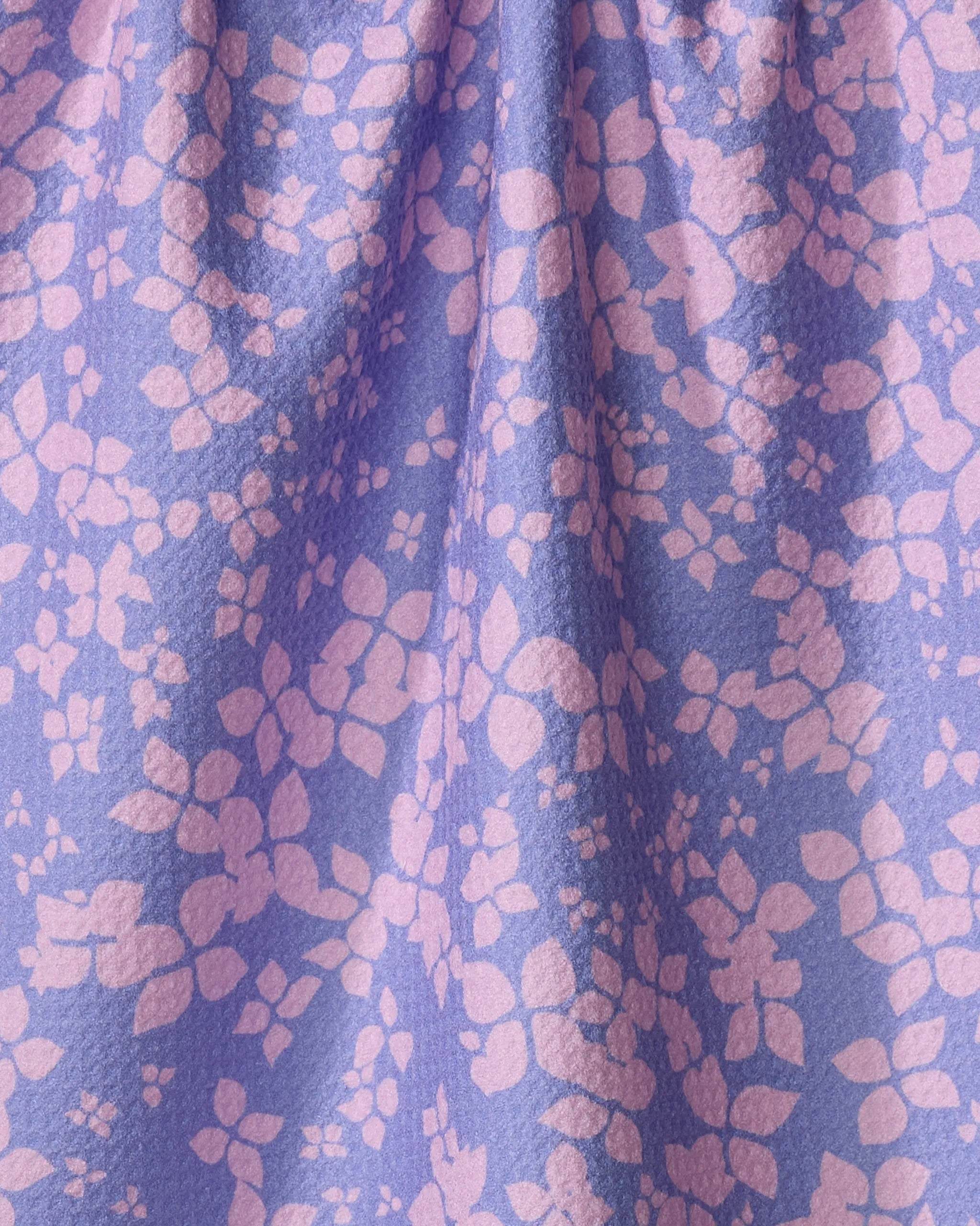 The Sareka Unique "You Give Me Butterflies" kitchen towel features purple fabric with scattered pink spots in an abstract print. Made from recycled materials, its softly gathered texture adds eco-friendly style to your space.