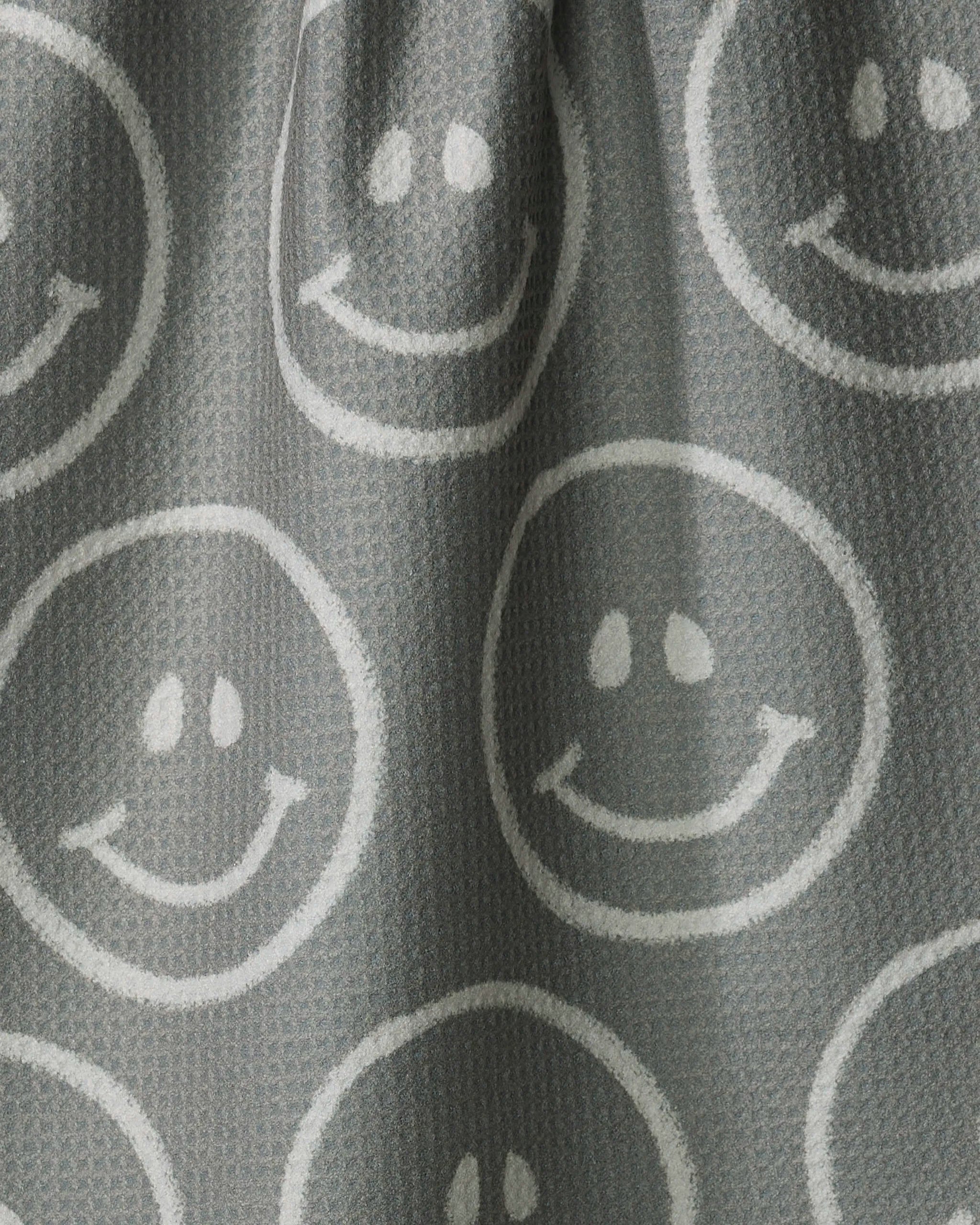 The "You Make Me Happy" towel by Kelsi Fullmer features gray textured fabric with white smiley faces in circles, offering a cheerful, playful design that's ultra-absorbent—ideal for brightening your kitchen.