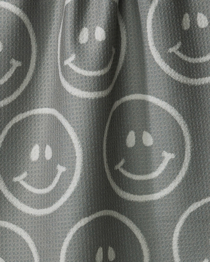 The "You Make Me Happy" towel by Kelsi Fullmer features gray textured fabric with white smiley faces in circles, offering a cheerful, playful design that's ultra-absorbent—ideal for brightening your kitchen.