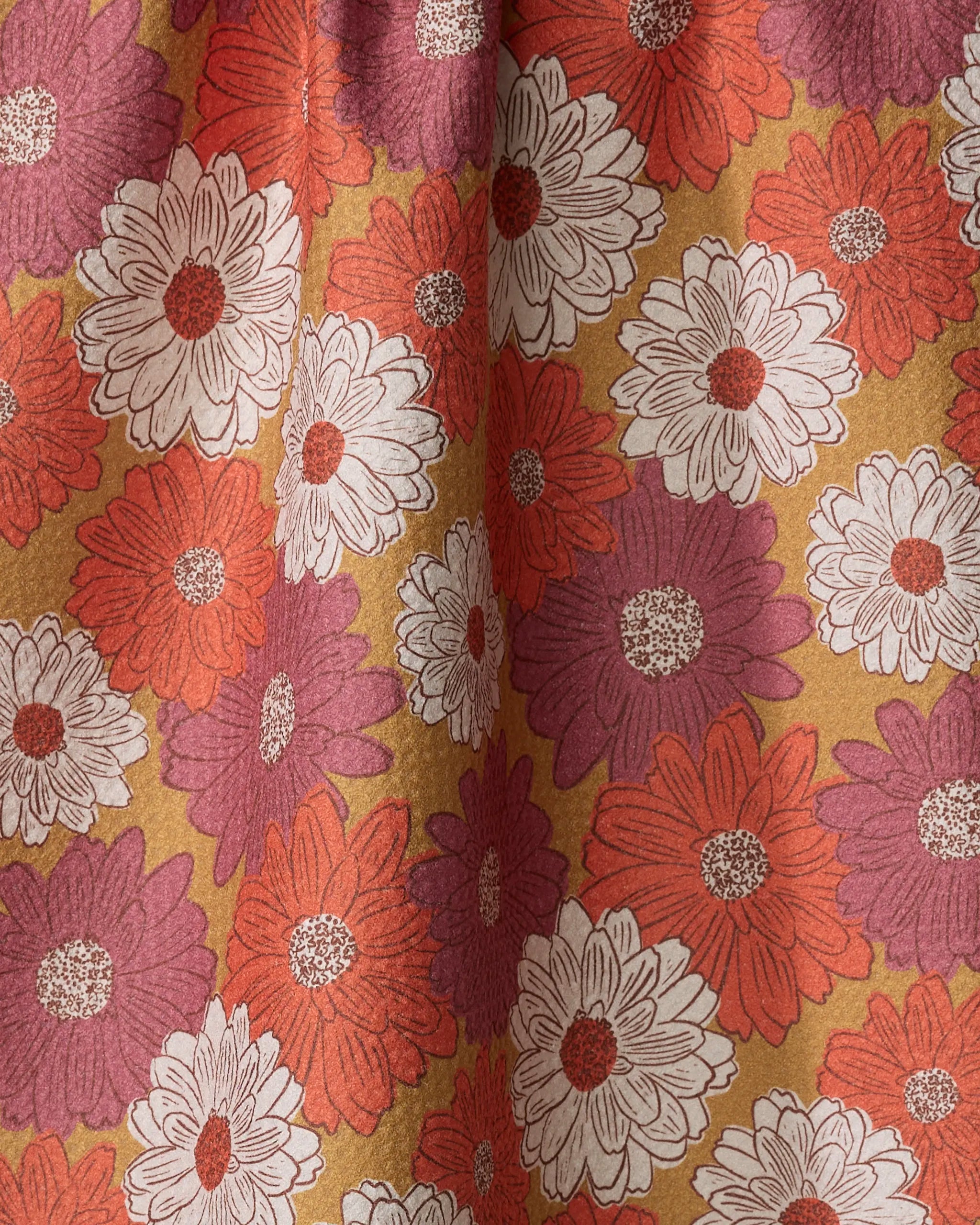 A close-up of the Kayla Ann Zinnia Forever recycled kitchen towel, featuring a floral pattern with large white, red, and purple daisies with brown centers on a muted yellow background. The absorbent fabric shows subtle folds and shadows.