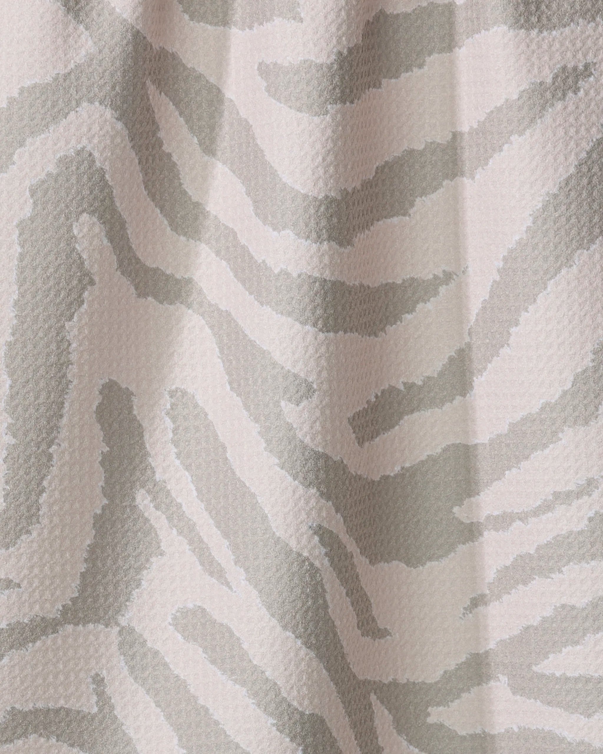 Close-up of Geometry’s Zira Gray tea towel, featuring an abstract zebra stripe pattern in light gray and white. Made from recycled materials, the wavy, irregular stripes offer a modern animal-inspired look.