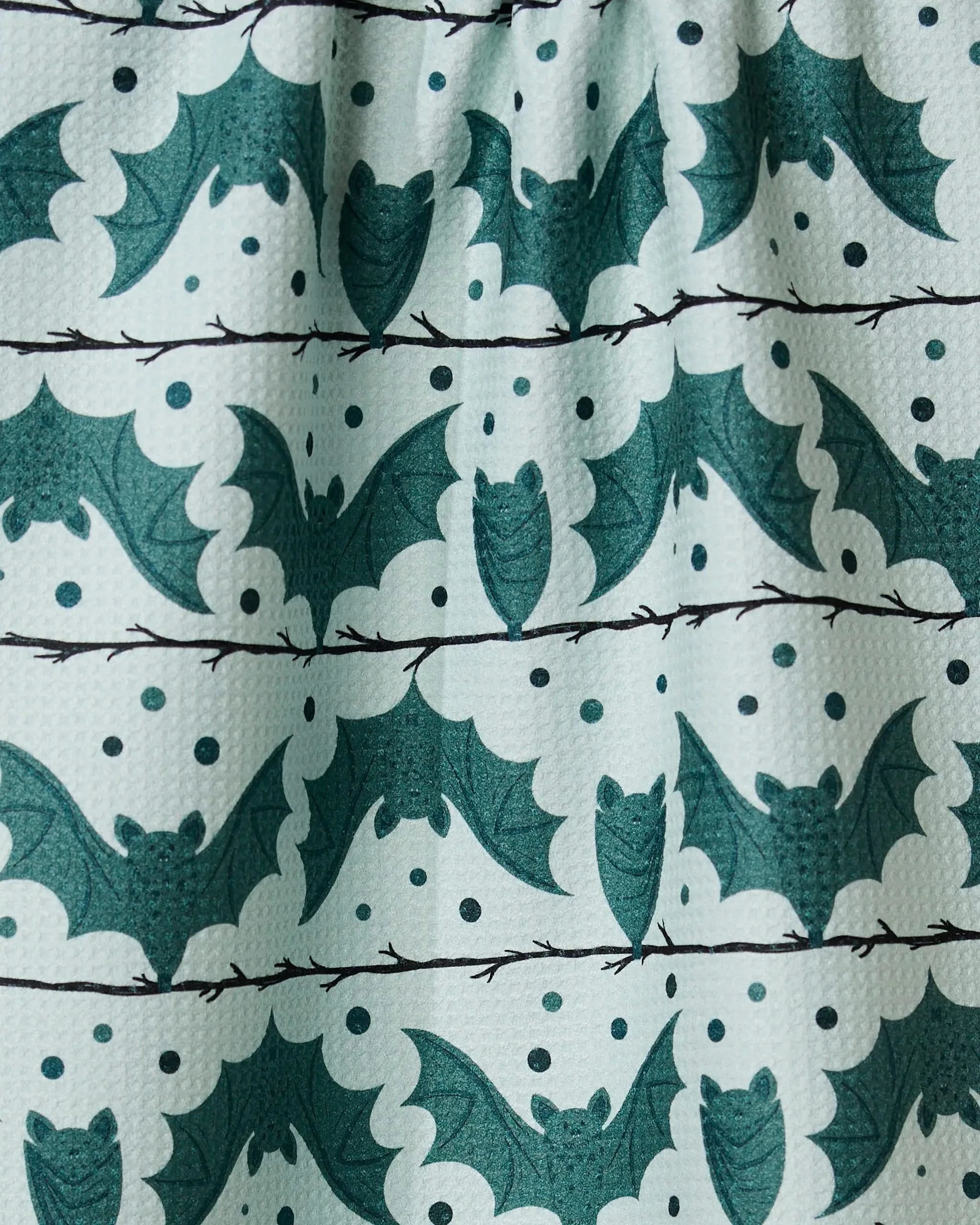 Geometry’s Bats Stripes and Dots tea towel features rows of green bats with polka dots and wavy lines on a light background, crafted from recycled materials.