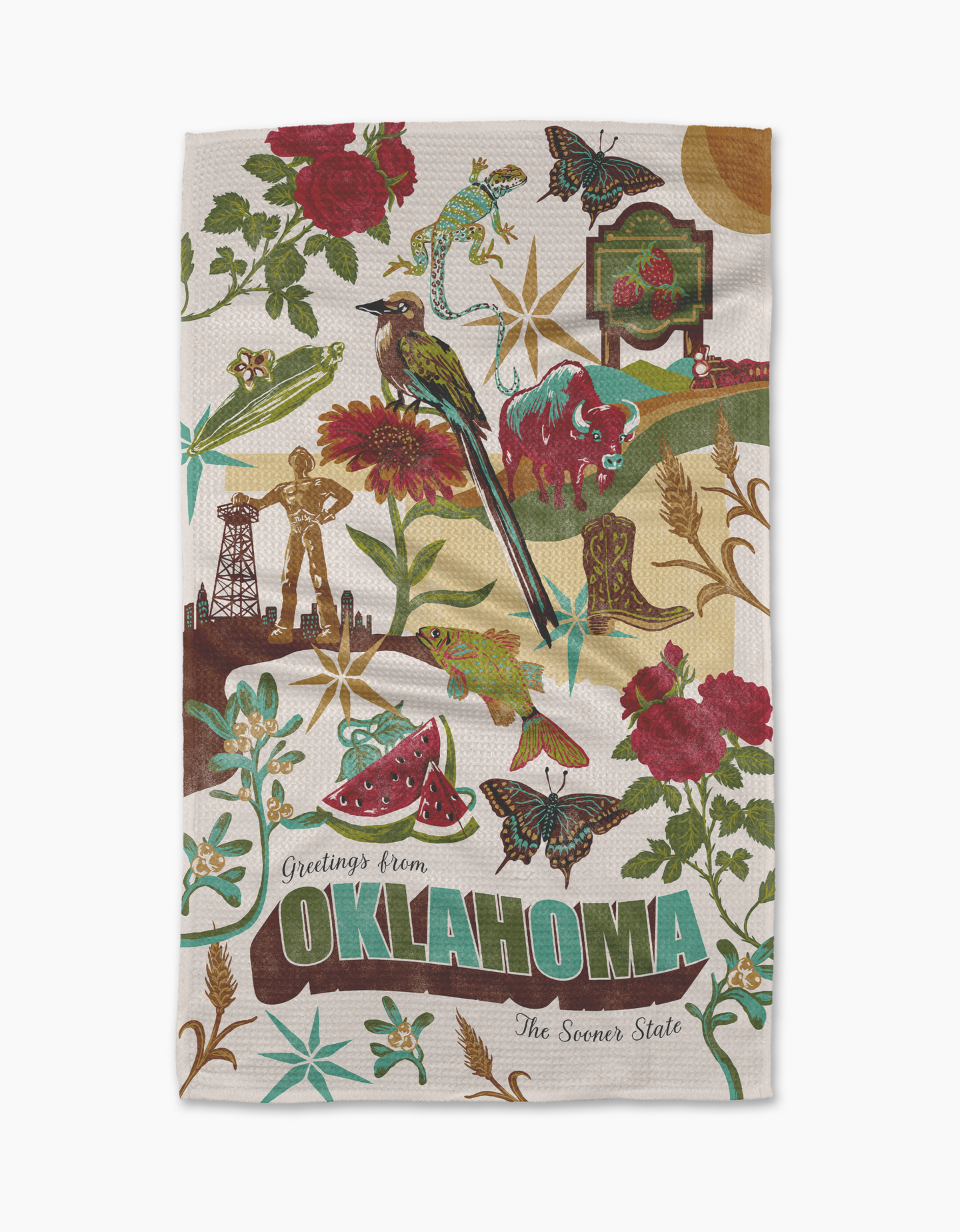 Geometry’s Greetings From Oklahoma tea towel showcases vibrant illustrations of iconic Oklahoma symbols—bird, flowers, butterflies, oil rigs, windmill, watermelon—and the phrase “Greetings from Oklahoma, The Sooner State.”.