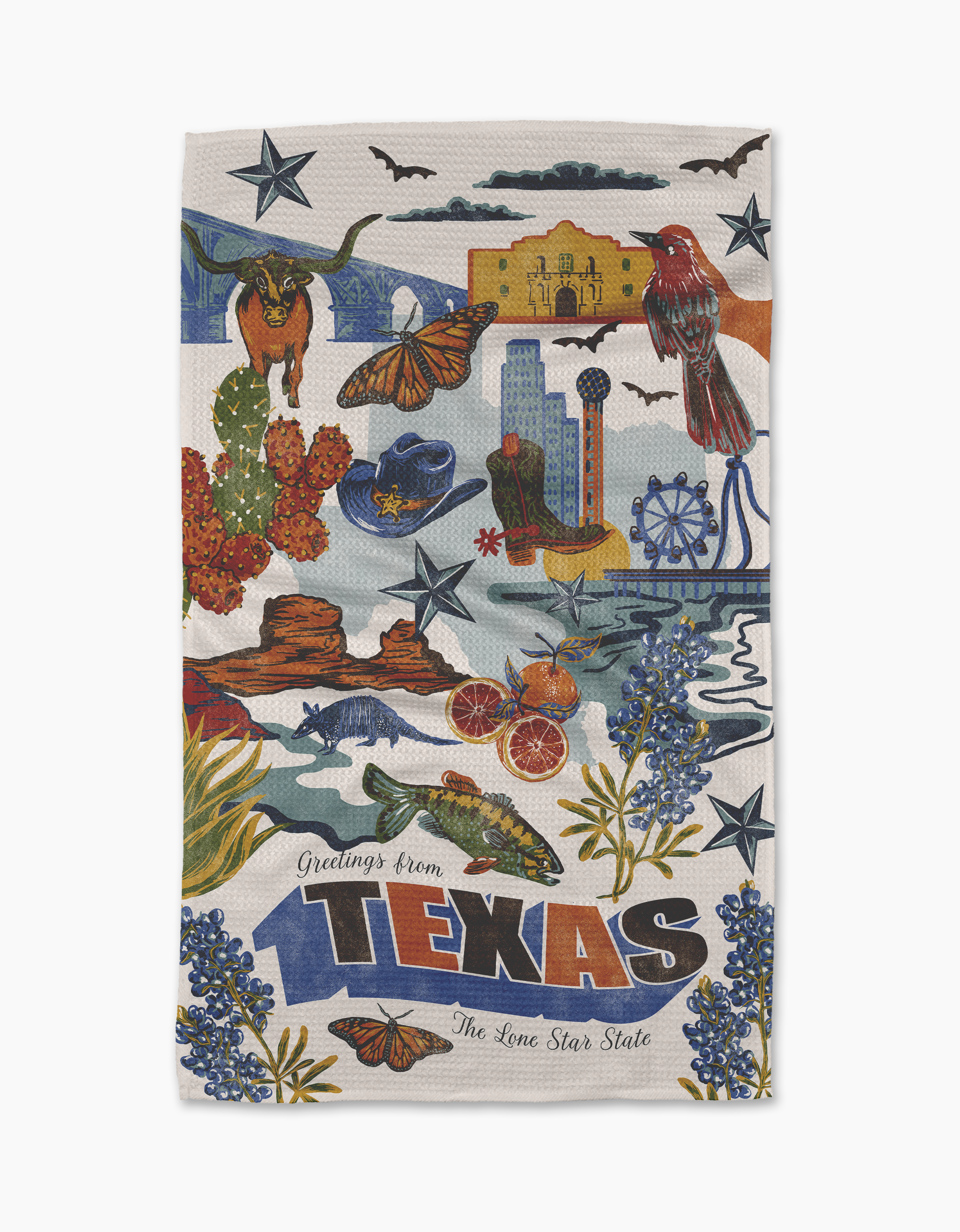 The Geometry "Greetings From Texas" recycled kitchen towel features colorful illustrations of Texas symbols—cactus, cowboy hat, armadillo, longhorn, bluebonnets, bat, citrus, river, and more—with text: Greetings from Texas, The Lone Star State.