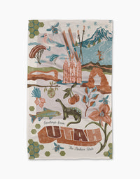 The Greetings From Utah illustrated postcard by Geometry features Delicate Arch, a skier, dinosaur, flowers, bees, and Salt Lake Temple with Greetings from Utah, The Beehive State—now on Geoweave fabric.