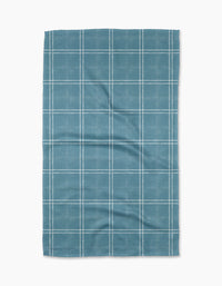 The Geometry Hearth Bay tea towel features a blue base with a white grid pattern. Ultra-absorbent and subtly wrinkled, this dish towel is shown laid flat against a white background.