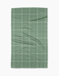 The Geometry Hearth Meadow is a green rectangular tea towel made from recycled materials, featuring a white grid pattern of evenly spaced lines and displayed flat on a white background.