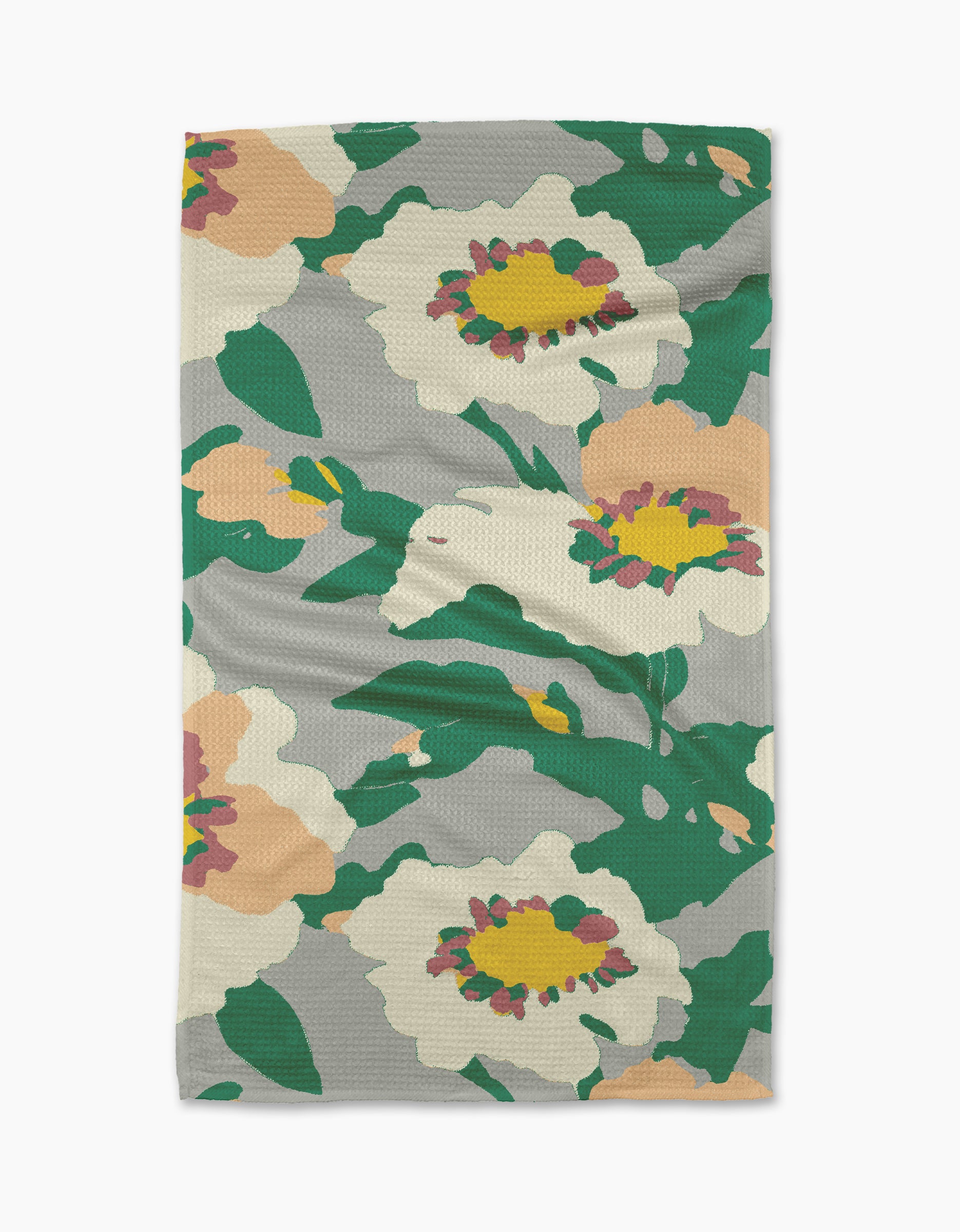 The Geometry Isla tea towel features large white, pink, and yellow flowers with green leaves on a light gray background. Its textured fabric offers both style and practicality for daily kitchen use.