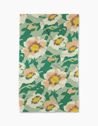 The Junie tea towel from Geometry features a colorful floral pattern with large peach and yellow flowers and green leaves on a light background, made from recycled materials.