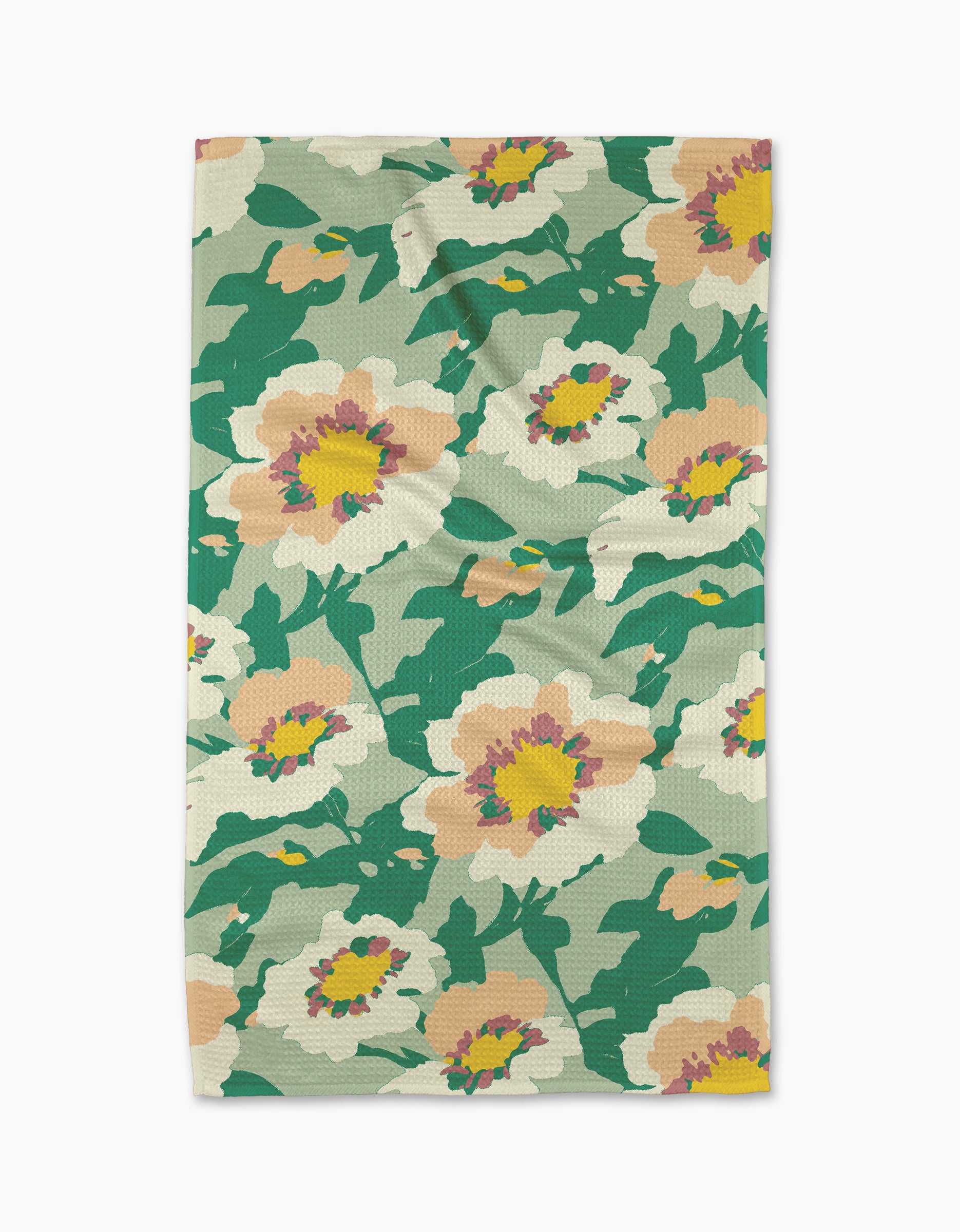 The Junie tea towel from Geometry features a colorful floral pattern with large peach and yellow flowers and green leaves on a light background, made from recycled materials.
