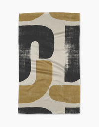 The Geometry Mono tea towel is ultra-absorbent and features a bold, abstract pattern with large black and mustard yellow curved shapes on a cream background, all with a brushed, textured look.