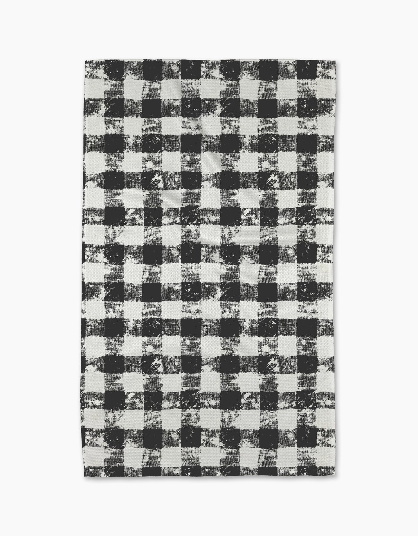 The Geometry Patch Ash tea towel features a black and white buffalo plaid pattern with a distressed, textured look on a white background.