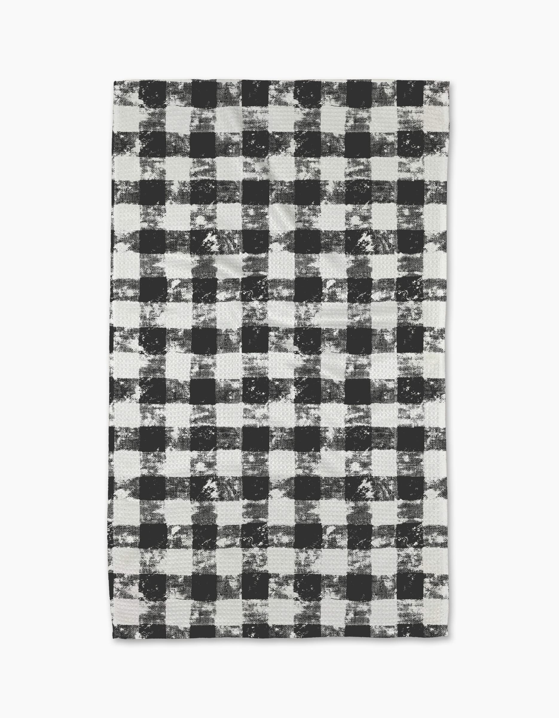 The Geometry Patch Ash tea towel features a black and white buffalo plaid pattern with a distressed, textured look on a white background.