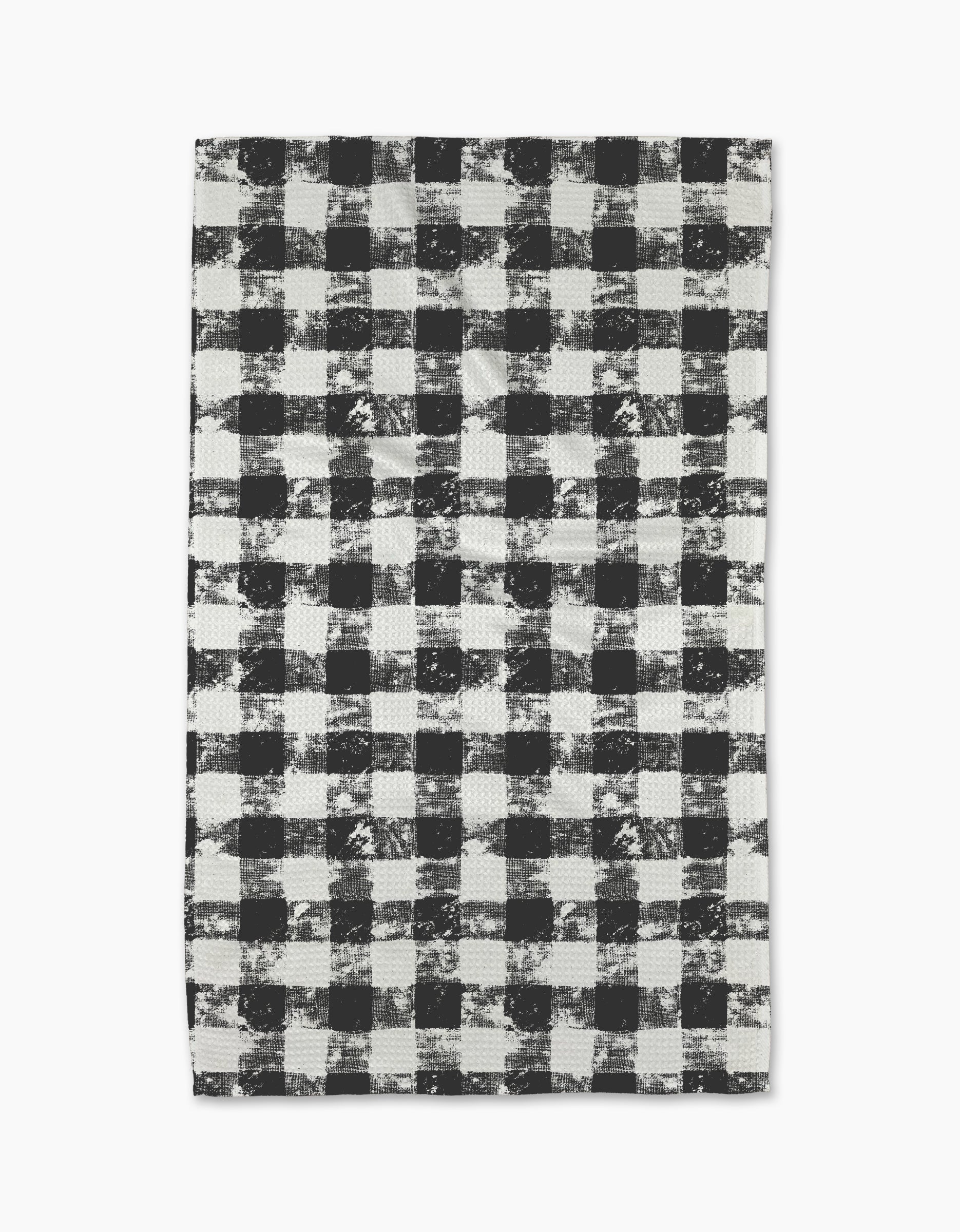 The Geometry Patch Ash tea towel features a black and white buffalo plaid pattern with a distressed, textured look on a white background.