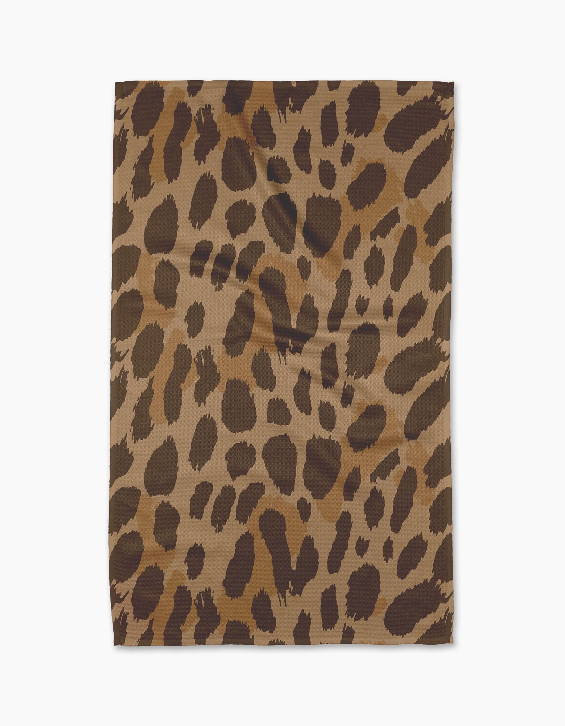 The Geometry Roam tea towel, crafted from recycled materials and showcasing a brown and black leopard print, is displayed flat on a white background.