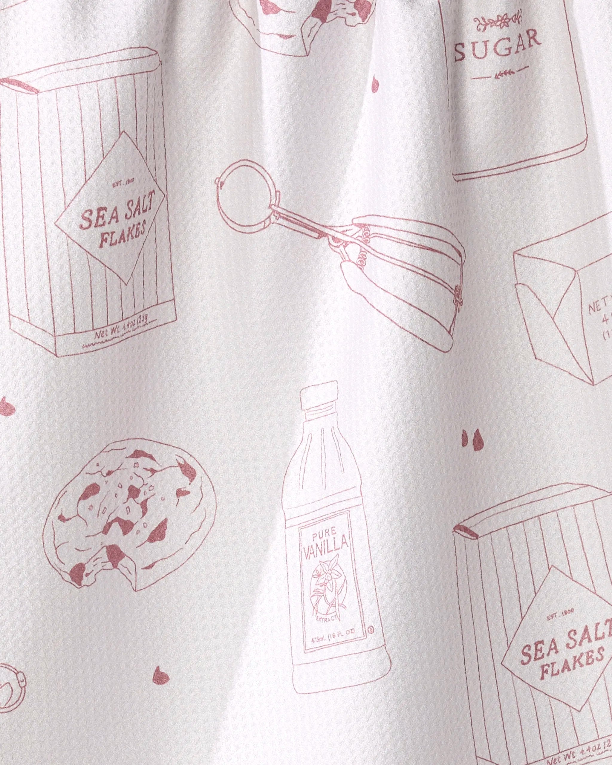 The "Salty" tea towel by Brooke Homec features pink line drawings of baking items on white and is made from recycled materials for an eco-friendly touch.