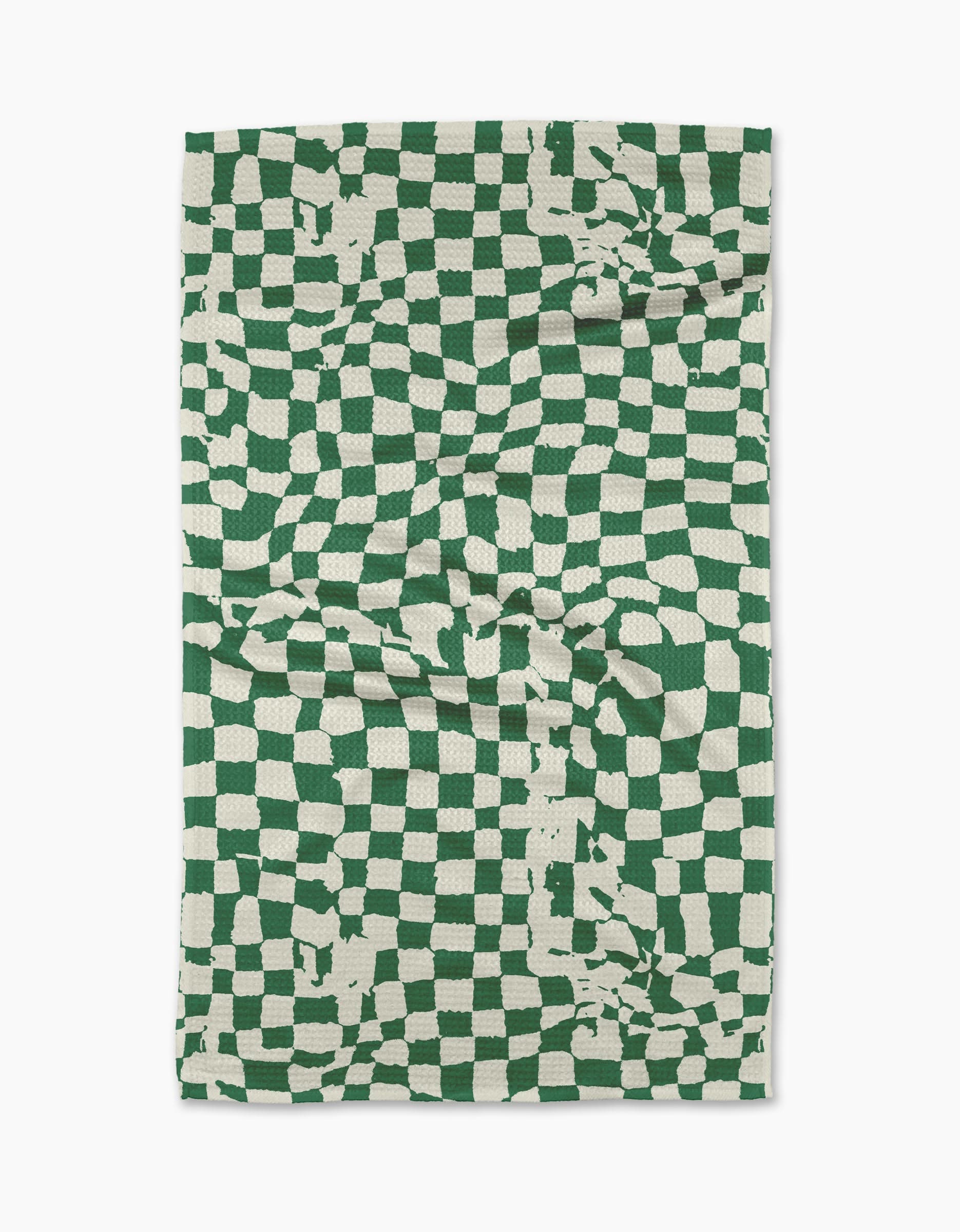 The Geometry Verdant tea towel is a rectangular, eco-friendly towel featuring a green and white distorted checkerboard with irregular lines and random splotches. Made from absorbent fabric, it’s shown slightly creased against a white background.