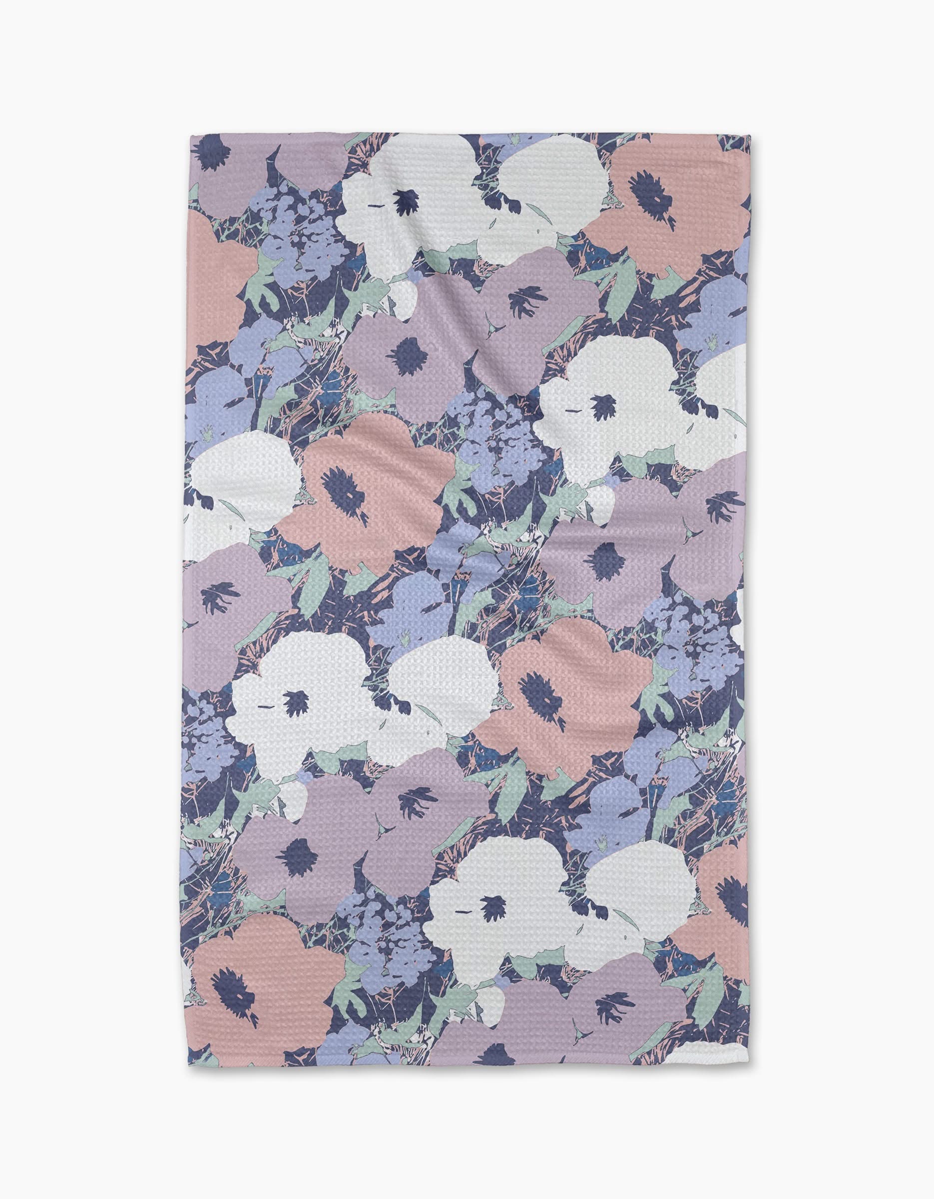 The Geometry Viola tea towel features a pastel floral design with large white, pink, and lavender flowers on a light background. Made from quick-drying, recycled materials for convenience and sustainability.