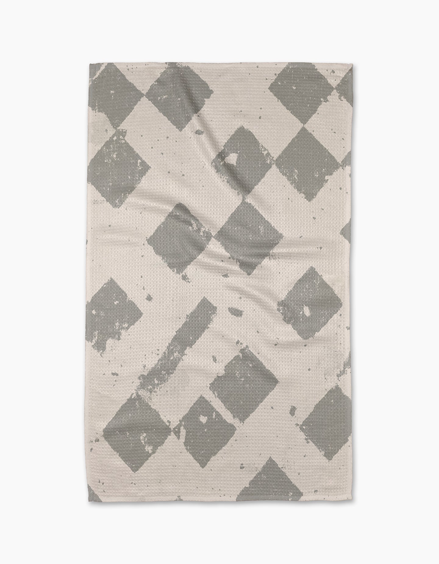 The Geometry Wisp Gray tea towel is rectangular and beige, featuring a gray diamond pattern with faded, distressed details, displayed flat on a white background.