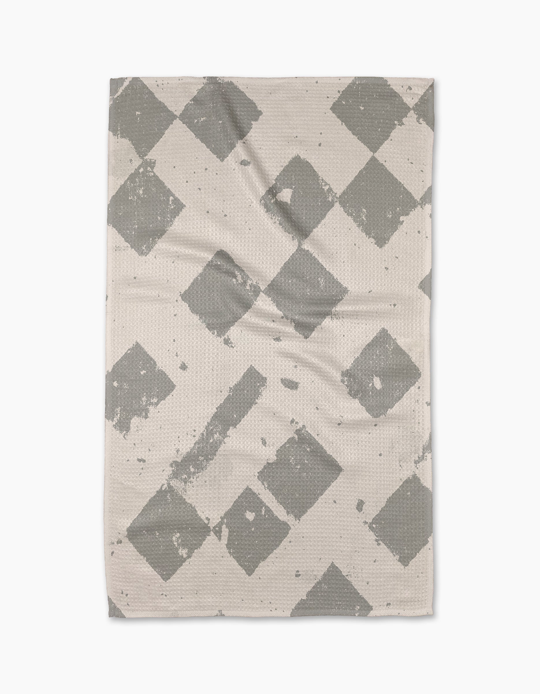 The Geometry Wisp Gray tea towel is rectangular and beige, featuring a gray diamond pattern with faded, distressed details, displayed flat on a white background.